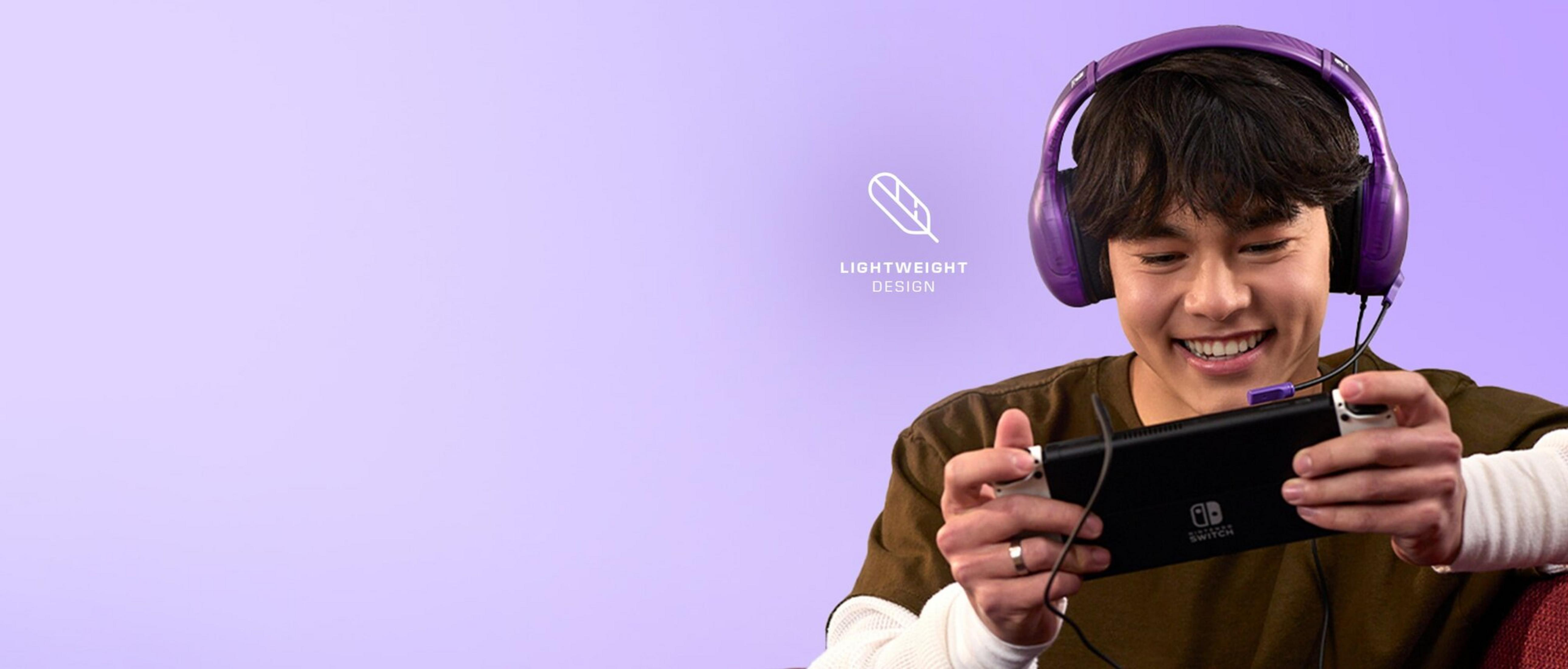 Młody mężczyzna w fioletowych słuchawkach gra na Nintendo Switch.