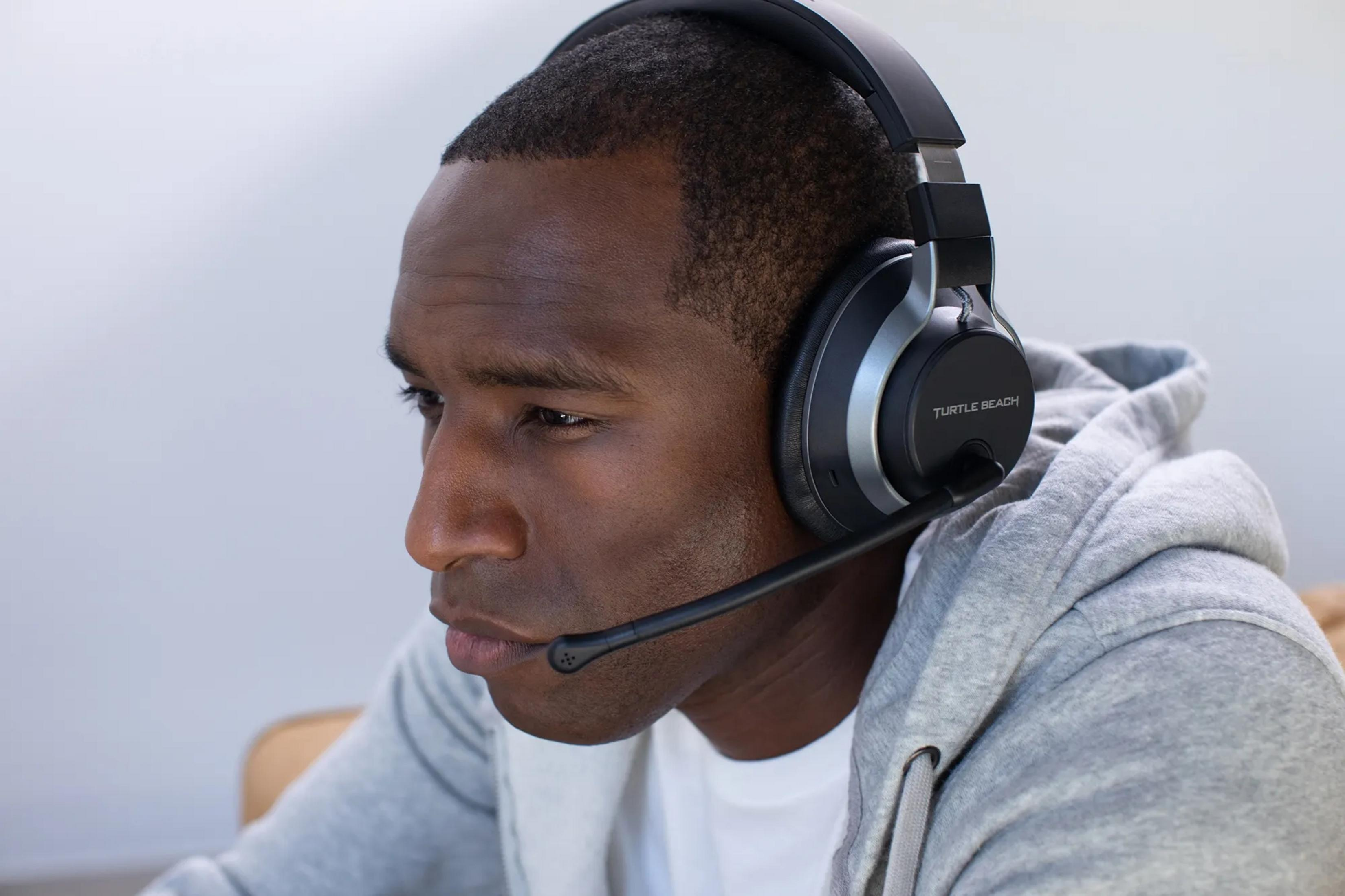 Mężczyzna w słuchawkach z mikrofonem, patrzący w lewo.
