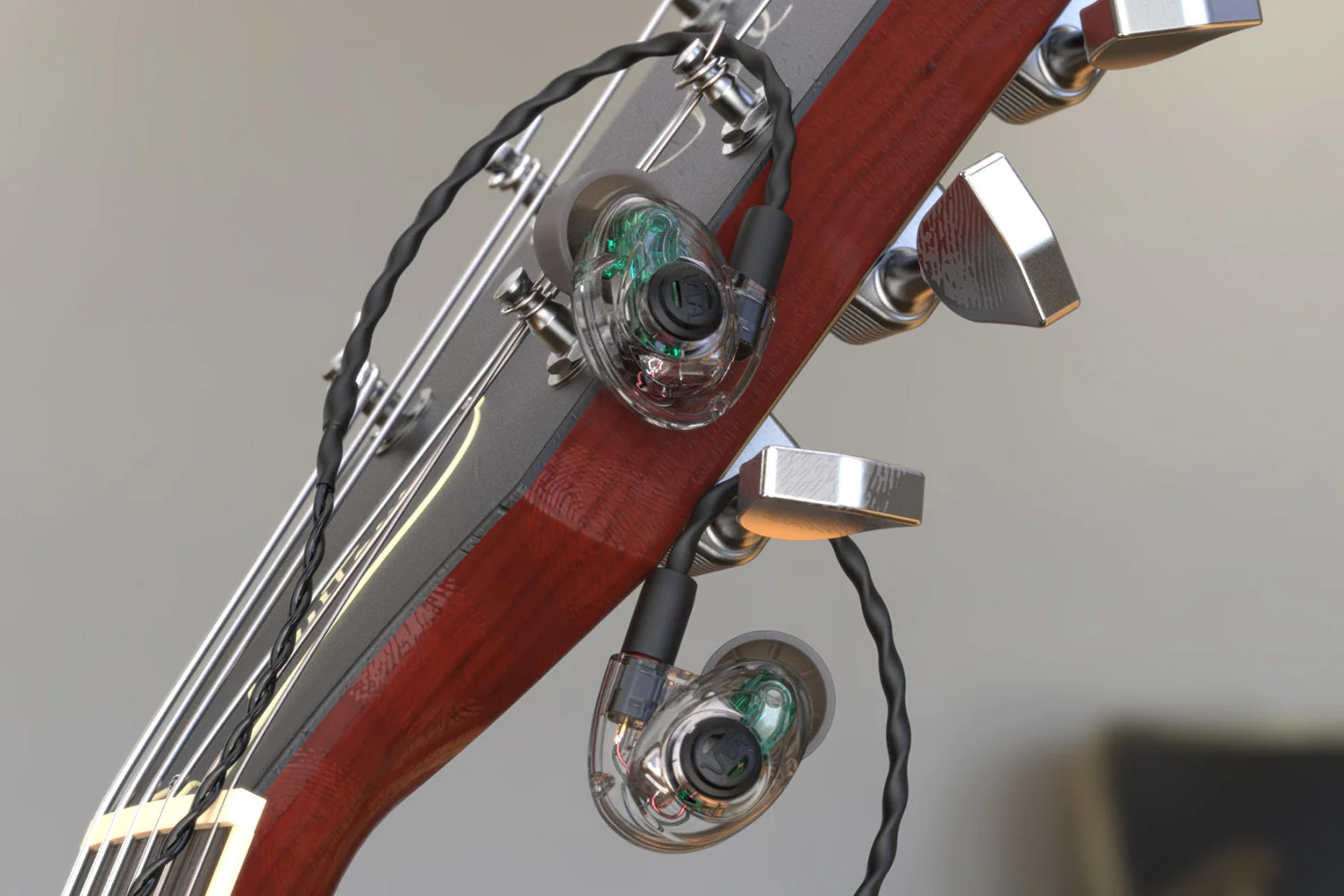 Nahaufnahme des Gitarrenhalses mit transparenten In-Ear-Monitoren und Schnüren.