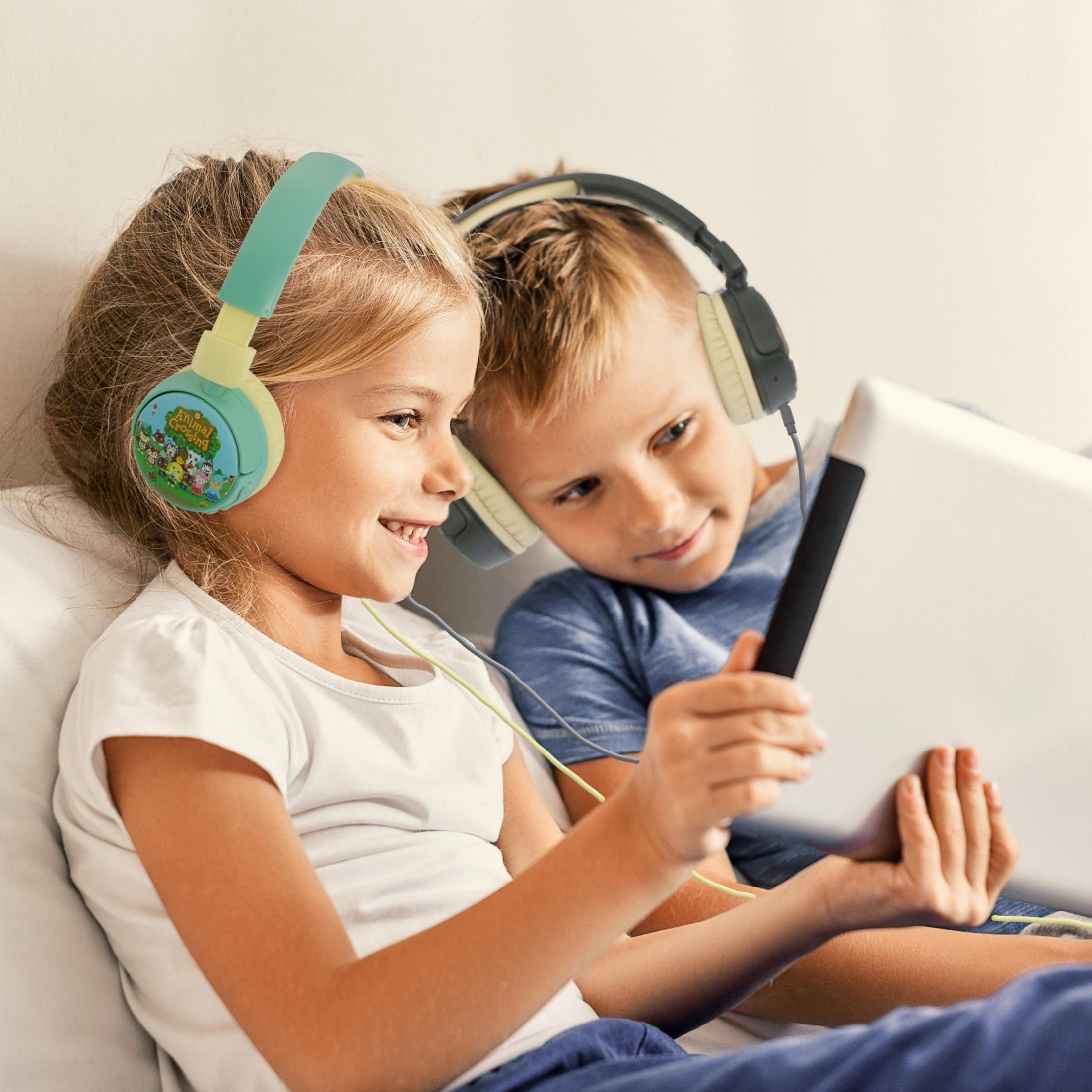 Twee kinderen met koptelefoons kijken naar een tablet.