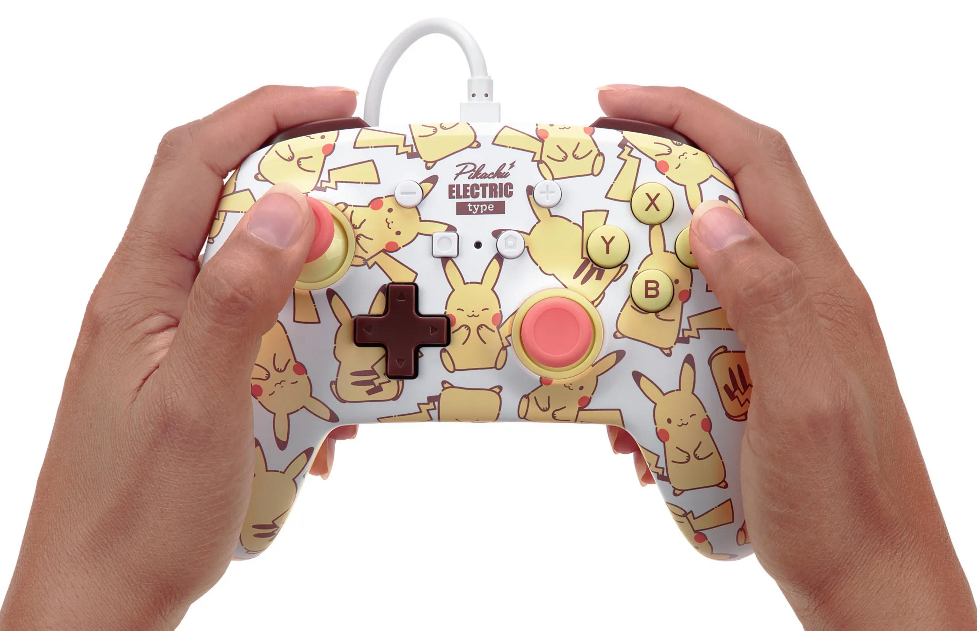 Hände halten einen weißen Controller mit Pikachu-Aufdruck.