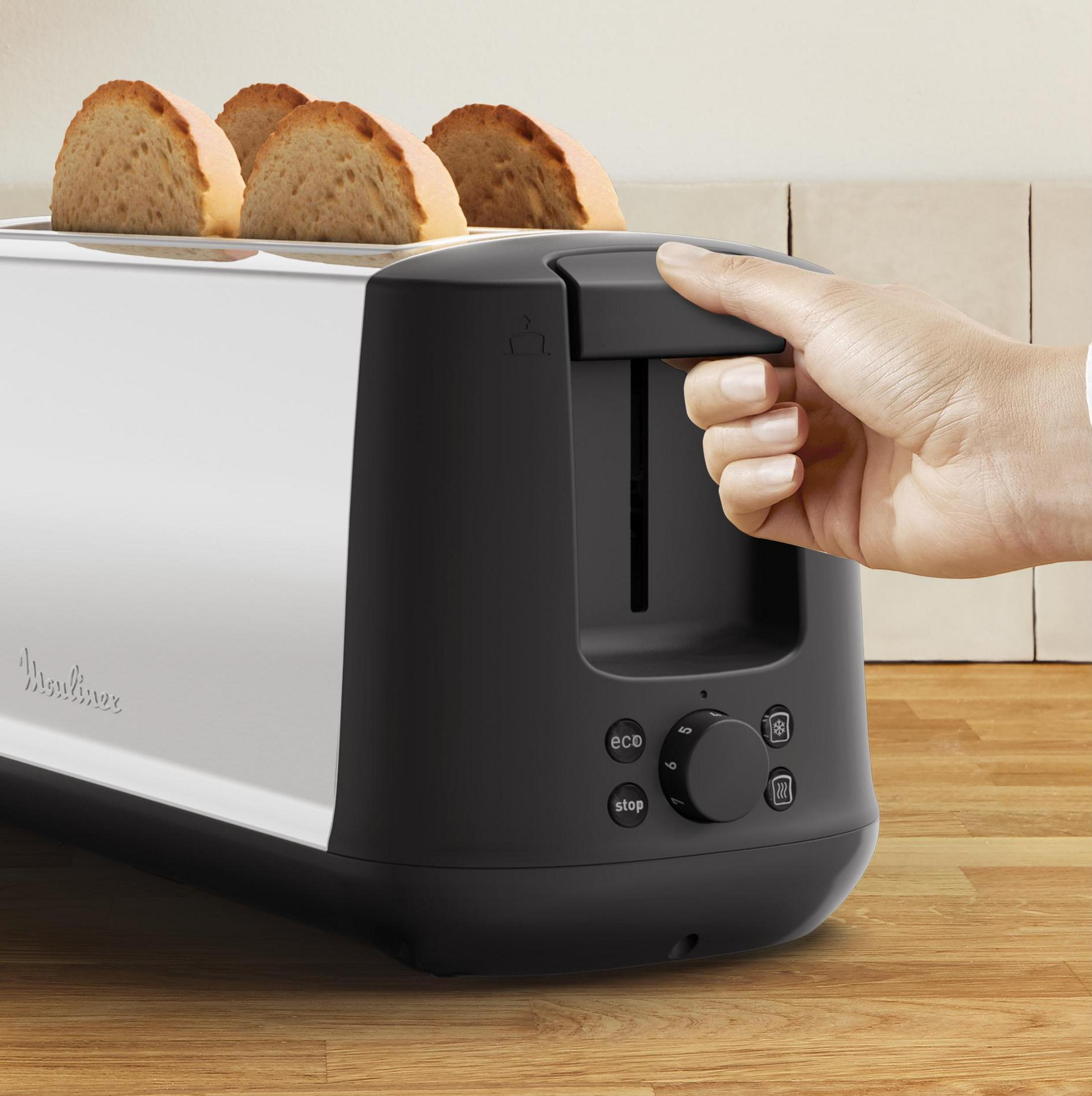 Toster z czterema kromkami chleba, uchwyt jest wciskany w dół.