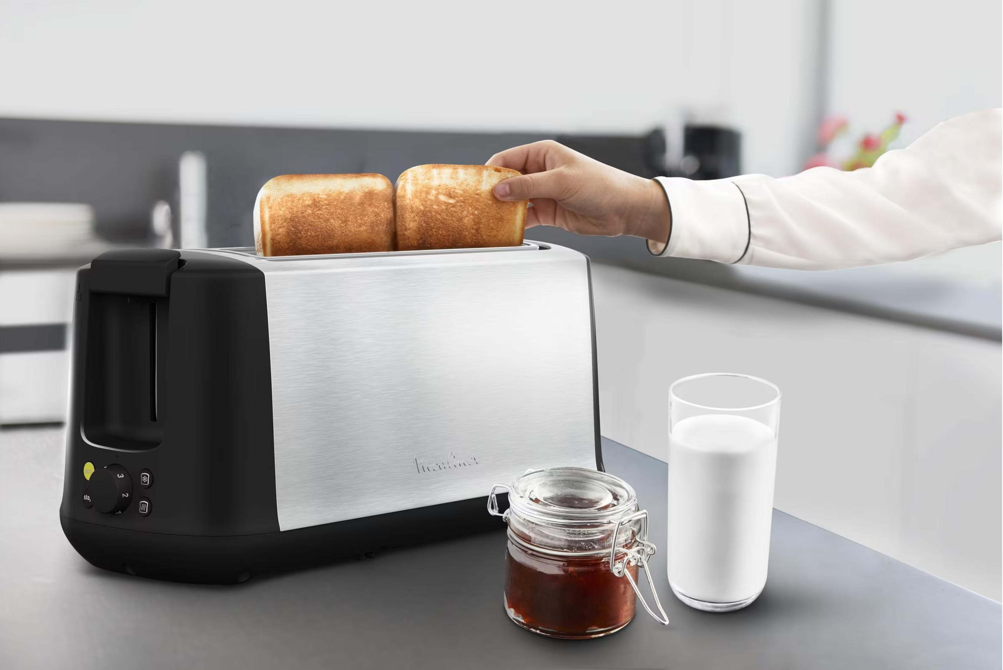 Toster z dwoma kromkami tostów, słoik dżemu i szklanka mleka obok.