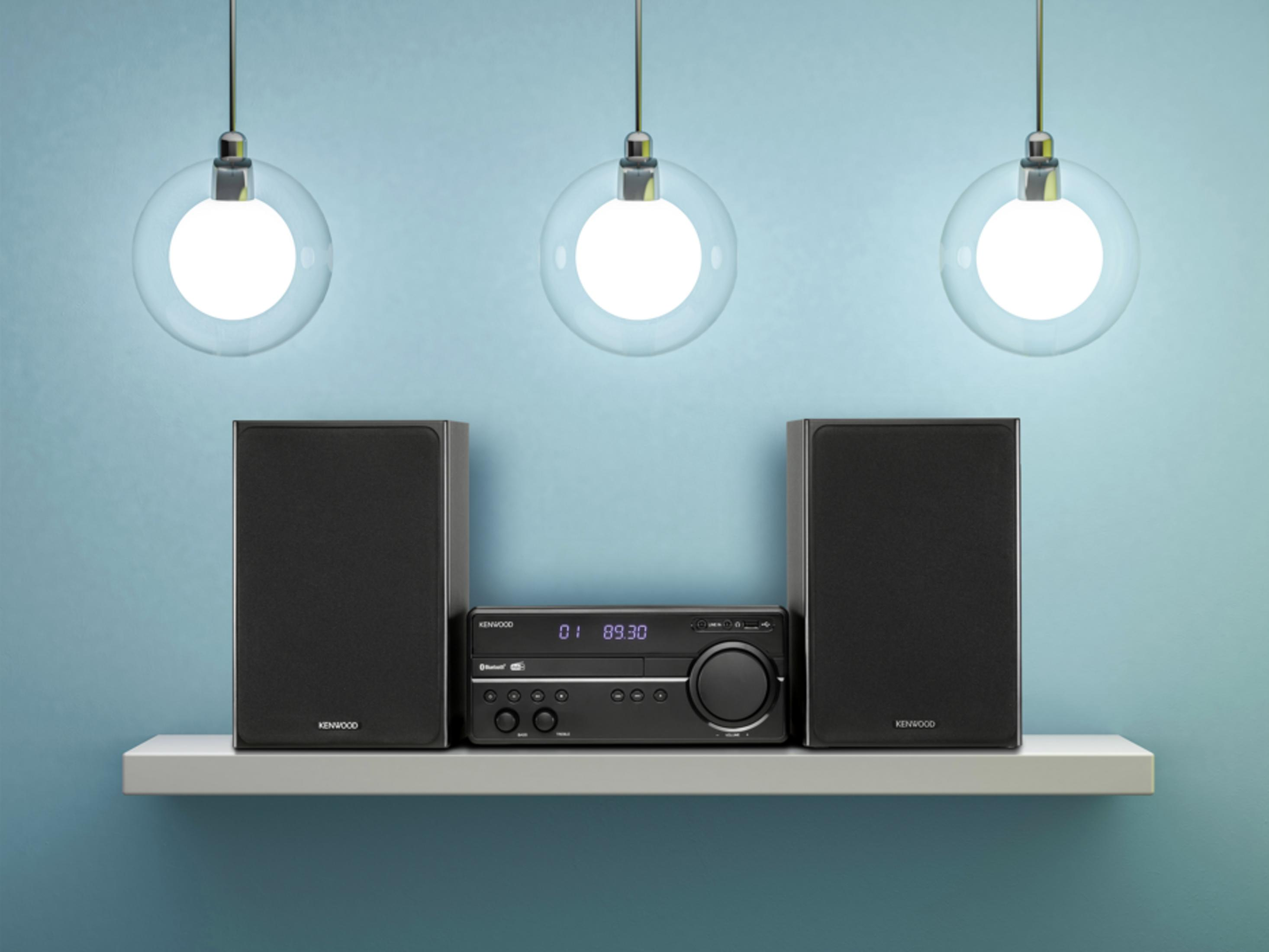 Un sistema estéreo Kenwood con dos altavoces y un reproductor de CD en un estante.