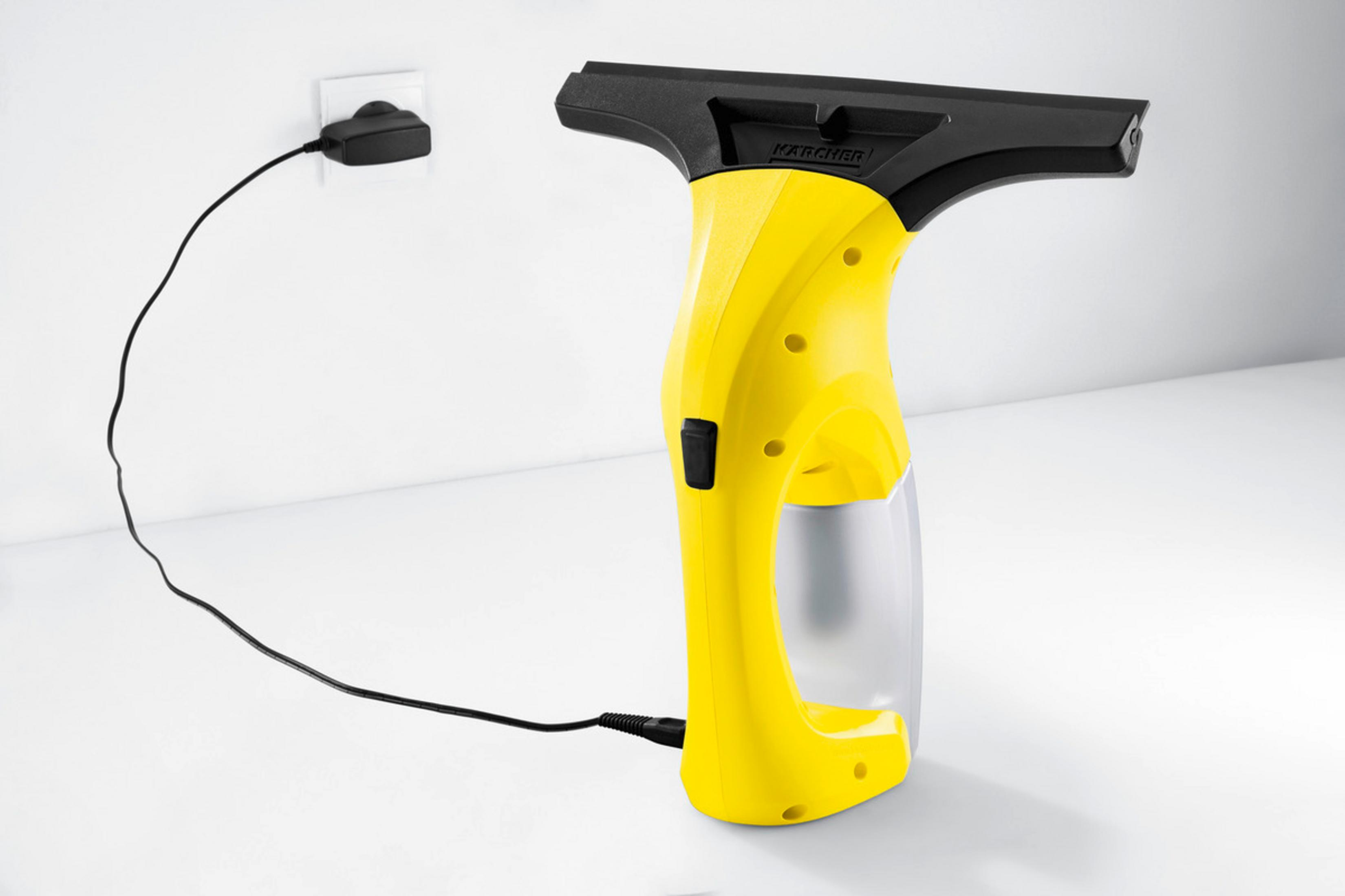 Siyah kablolu sarı Karcher pencere temizleyici prize takılı.