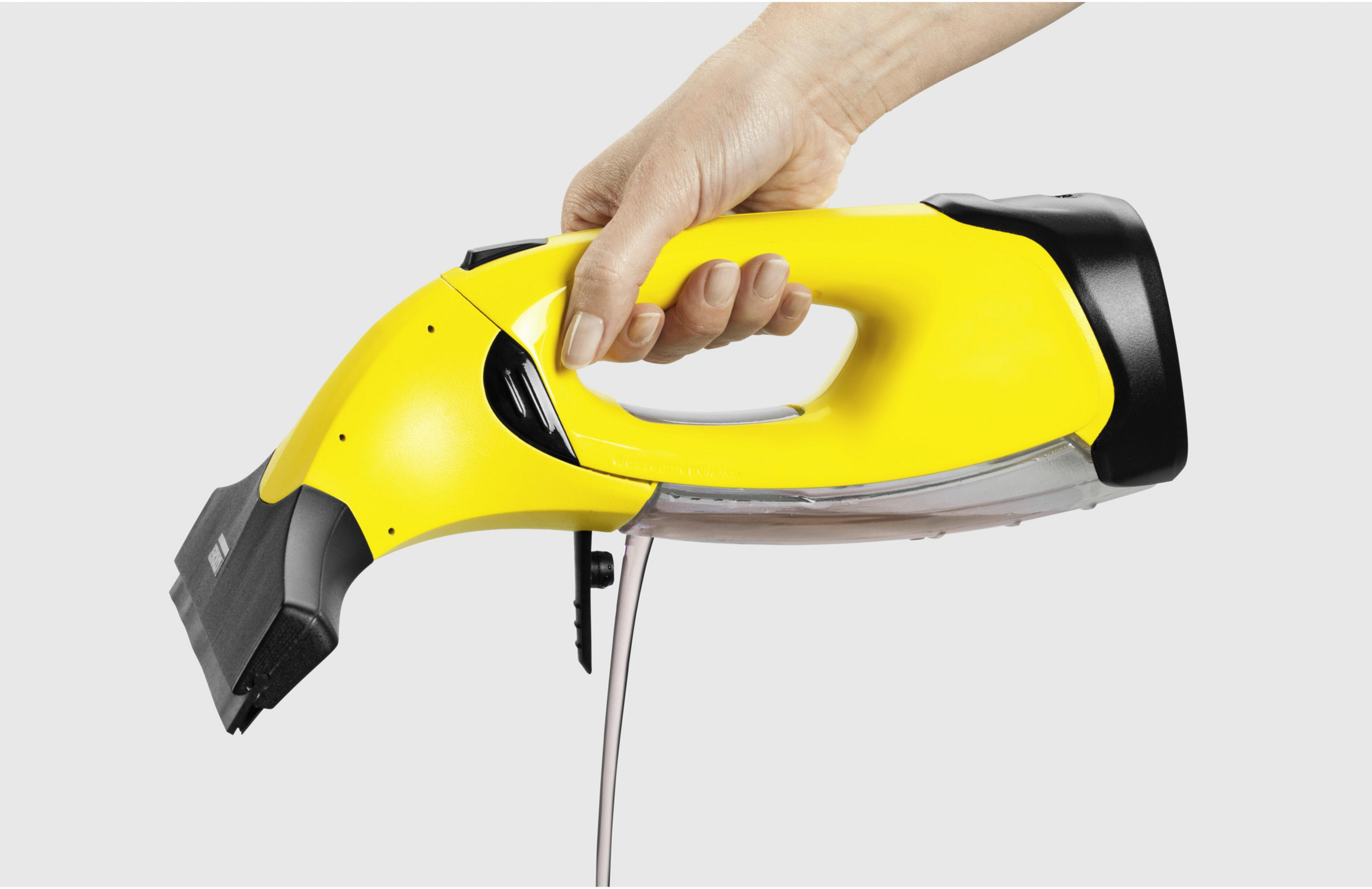 Una mano tiene un dispositivo di pulizia giallo da cui gocciola liquido.