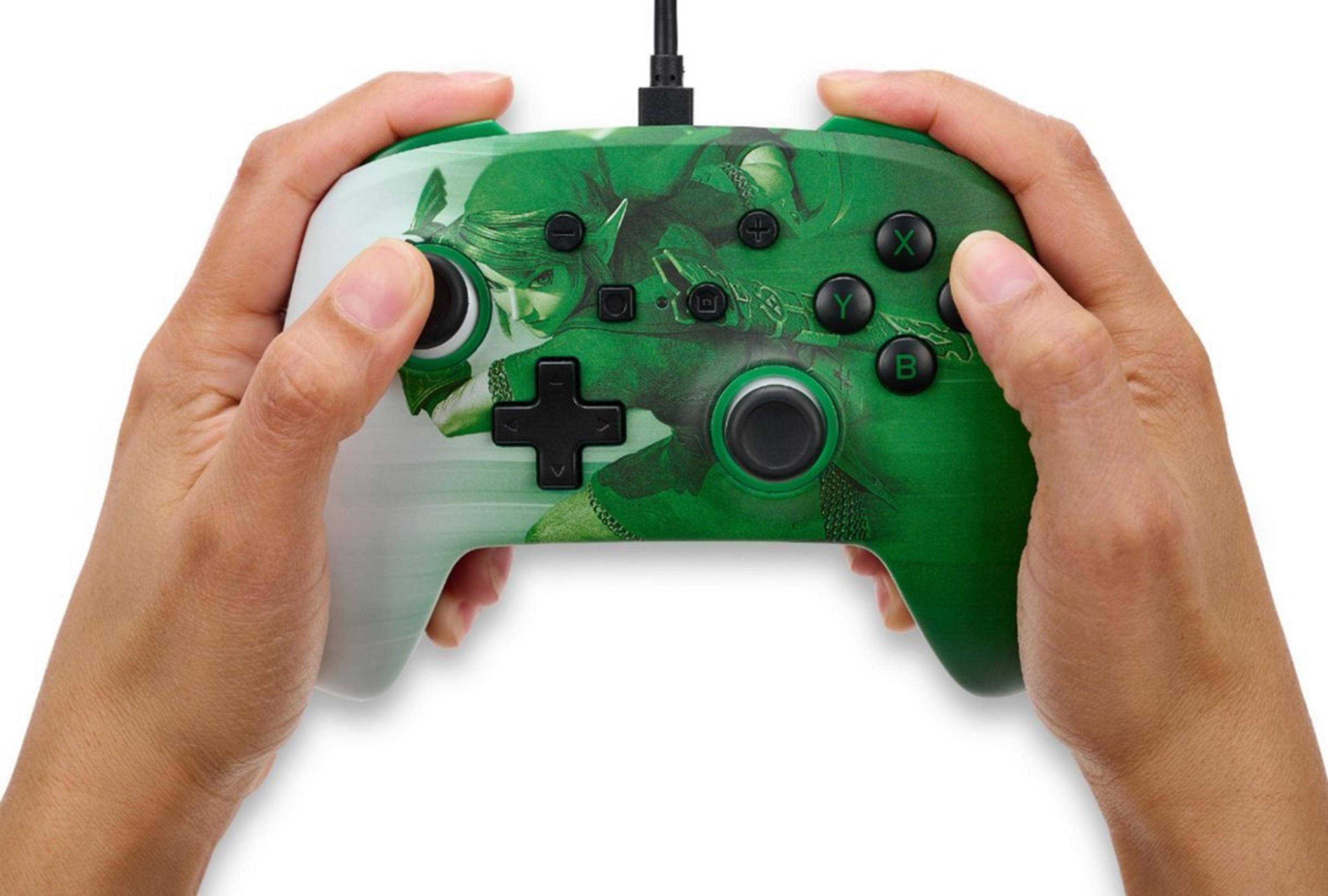 Grüner Controller mit Link-Motiv, gehalten von Händen.