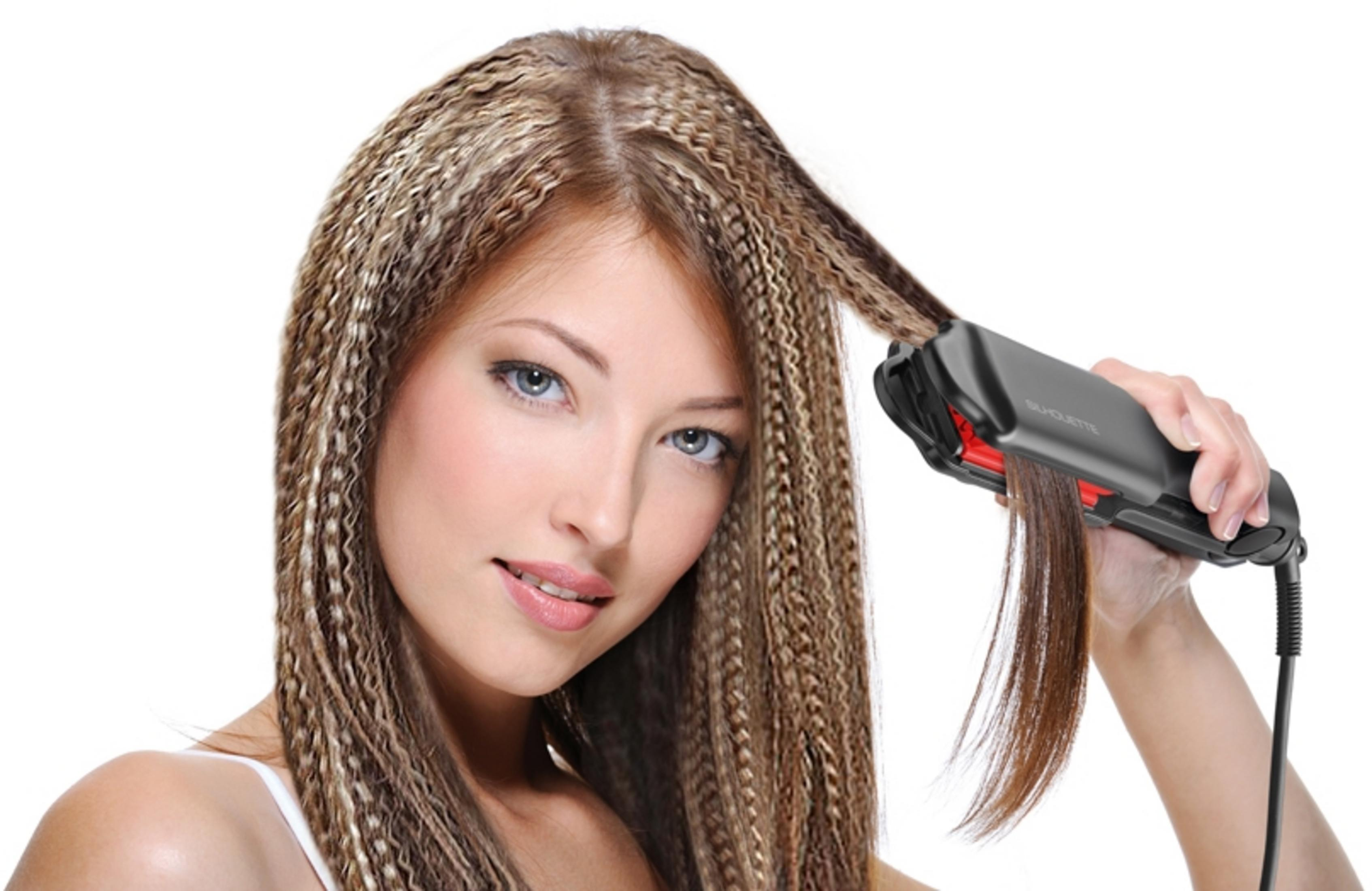 Frau stylt ihr Haar mit einem Glätteisen für einen zerknitterten Look.