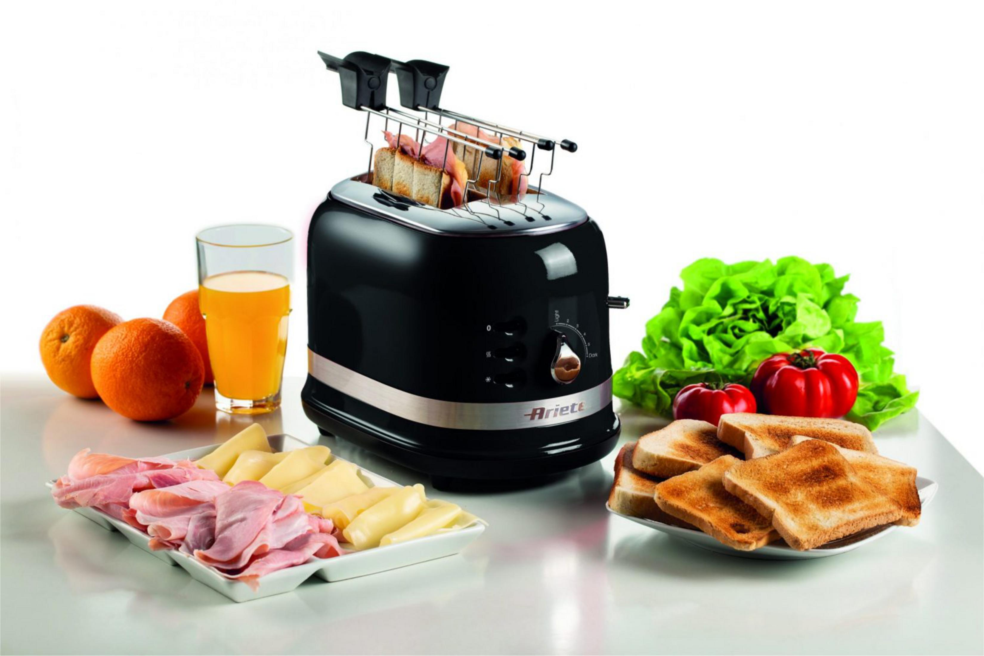 Zwarte broodrooster met toast, ham, kaas, sinaasappels, sap, tomaten en sla.