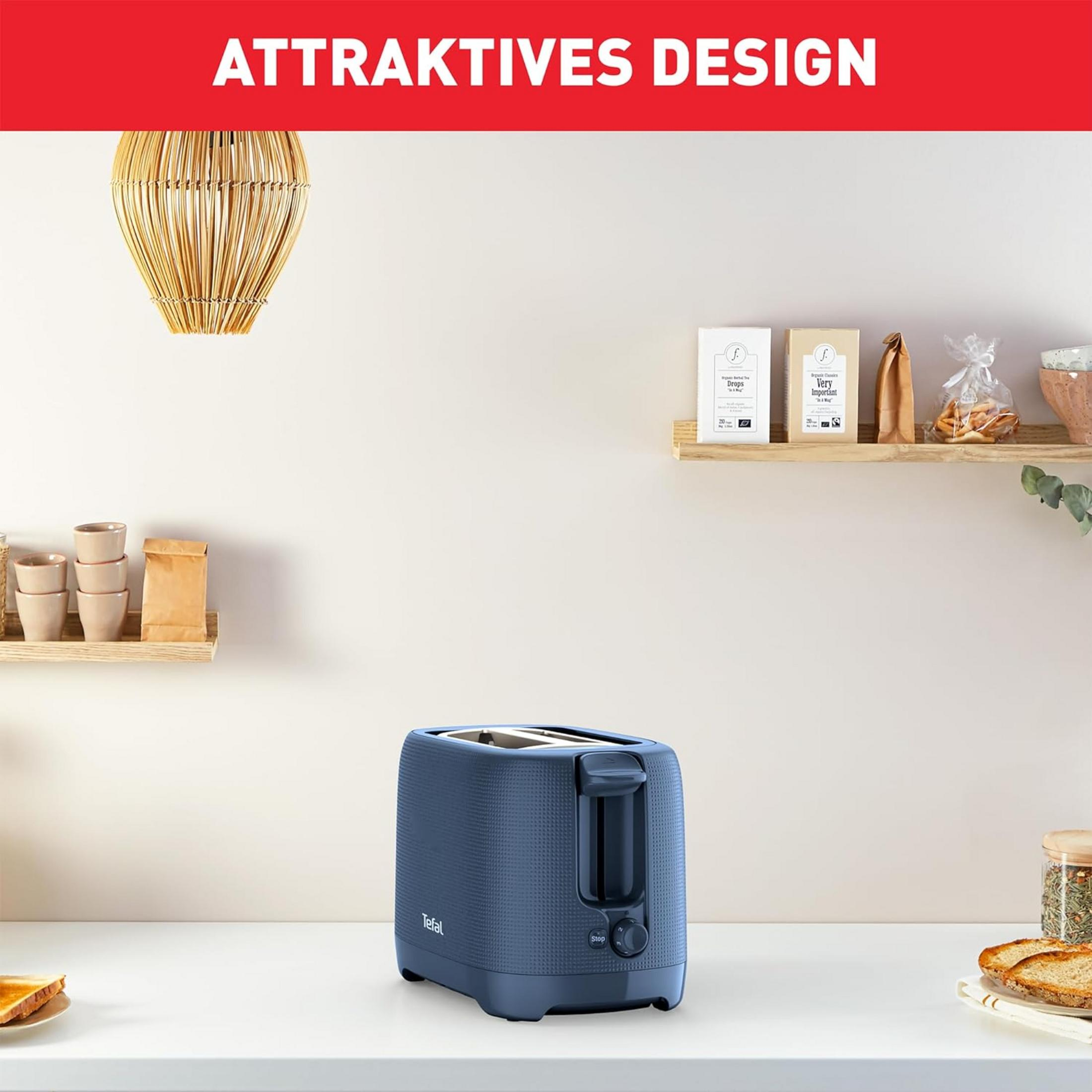 Ein dunkelblauer Toaster steht auf einer weißen Arbeitsplatte mit Toast und Gewürzen.