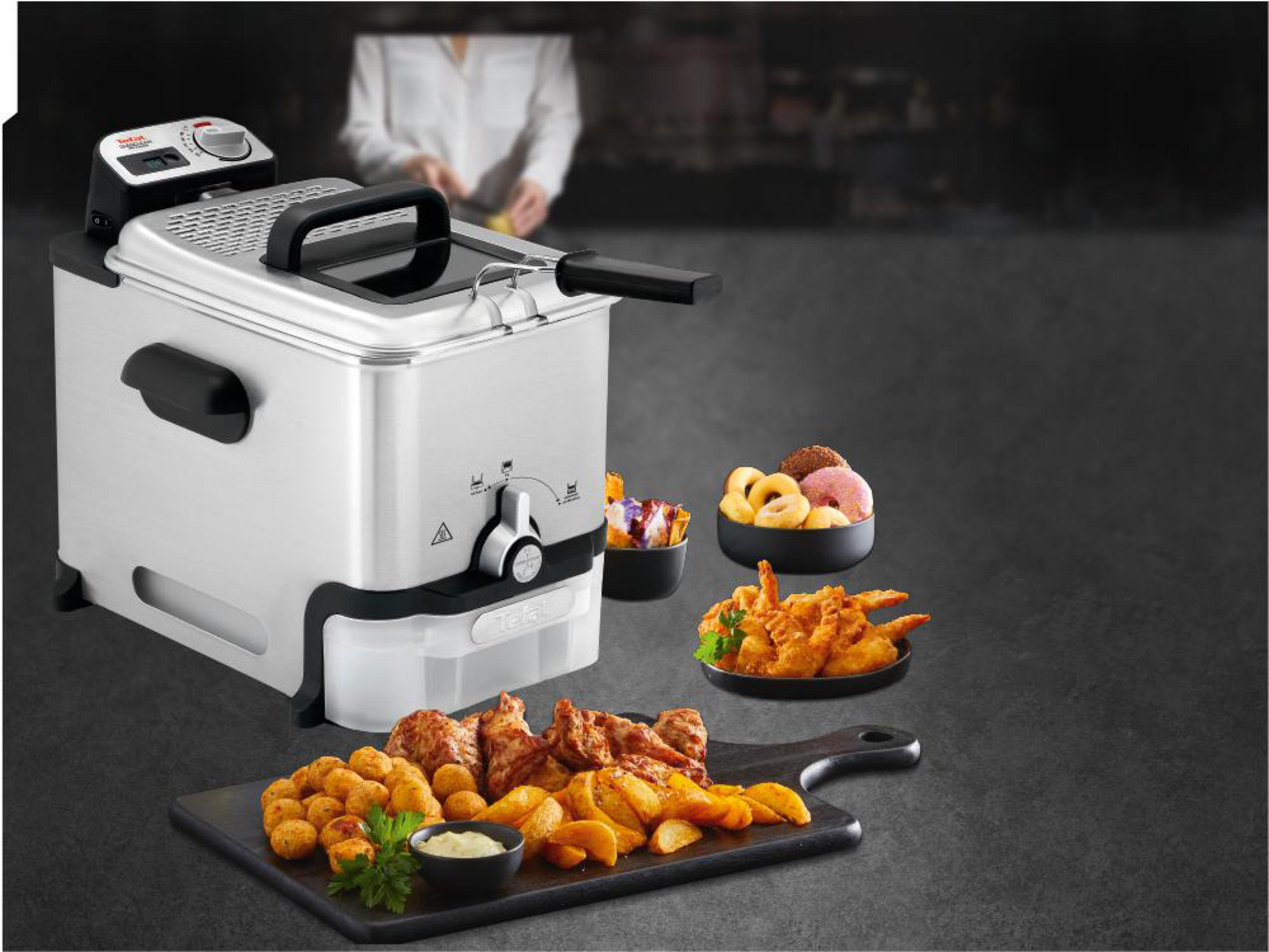 Srebrna frytkownica z smażonymi potrawami, takimi jak krewetki, pączki i ziemniaki.