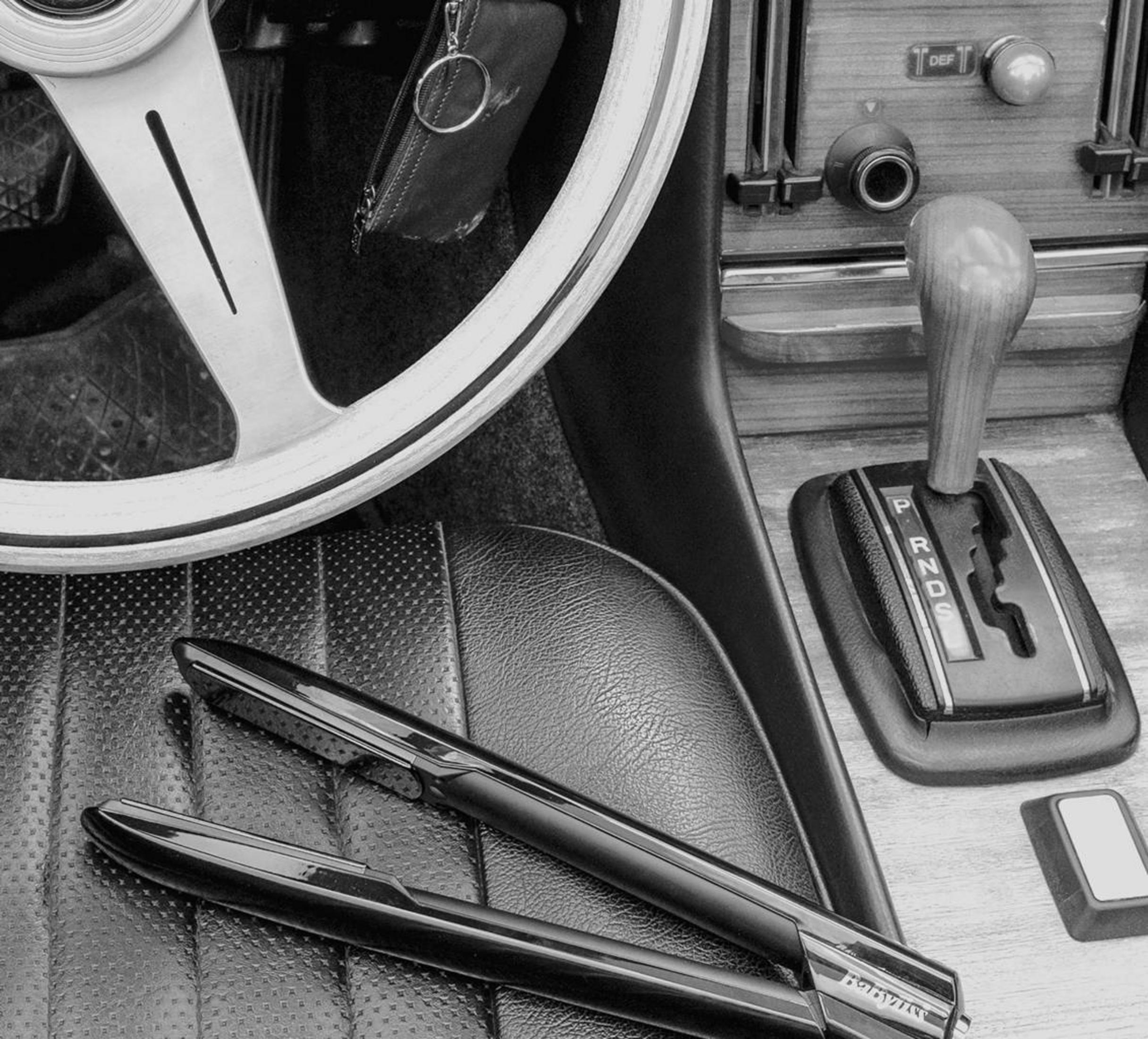 Innenraum eines Autos mit Lenkrad, Gangschaltung und zwei Stiften auf dem Sitz.