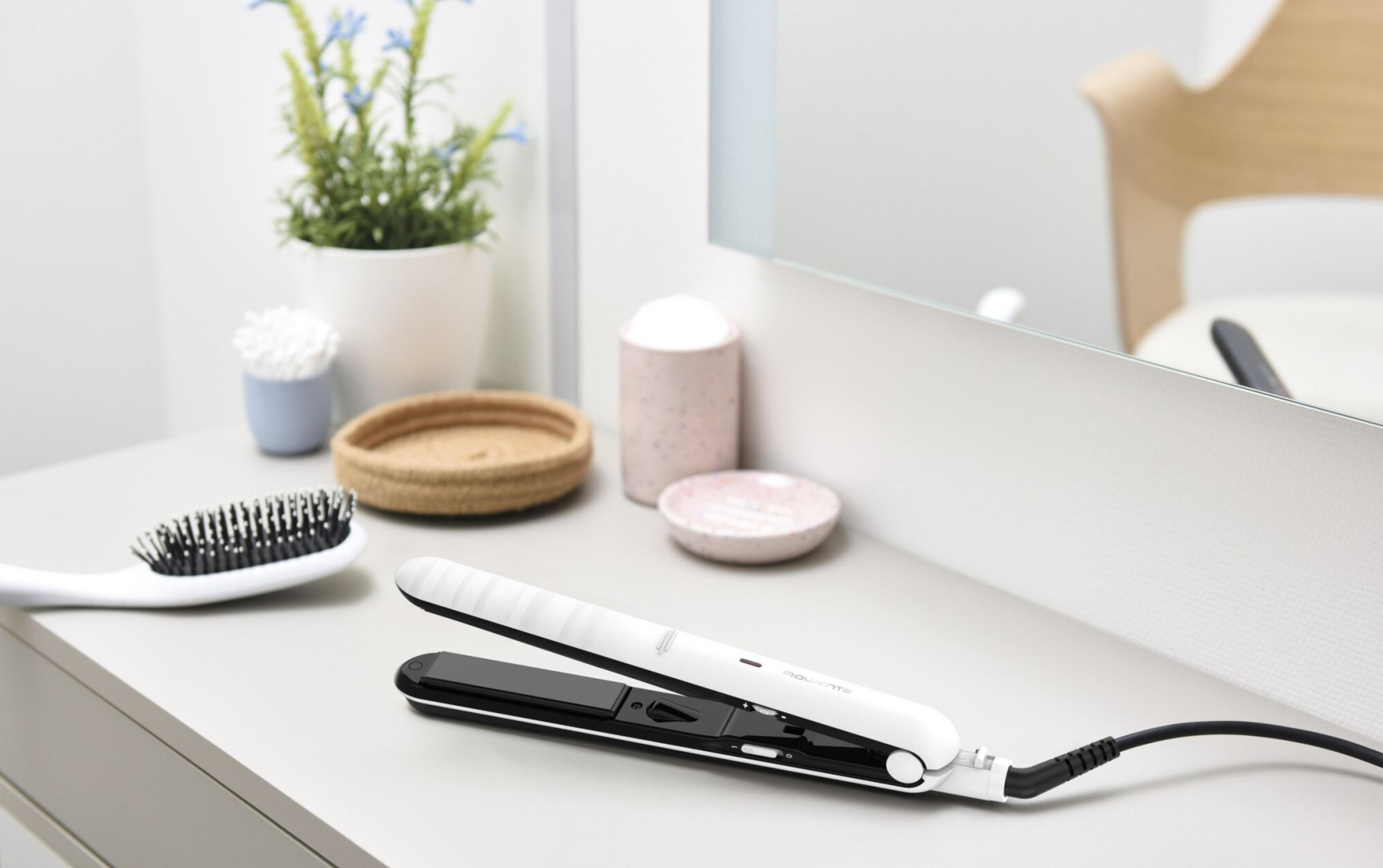 Una plancha de pelo blanca yace sobre una mesa, junto a un cepillo.