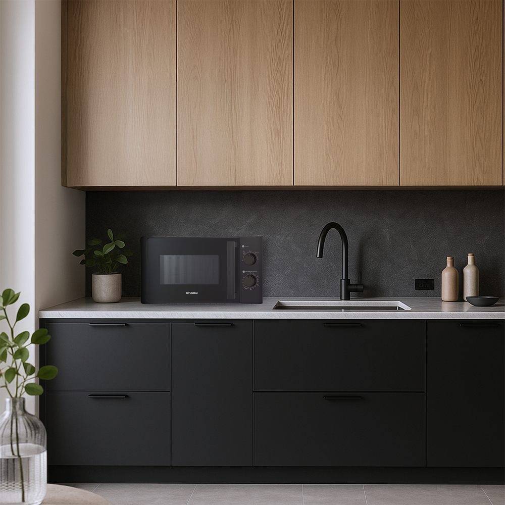 Microondas negro en encimera de cocina con armarios de madera arriba.