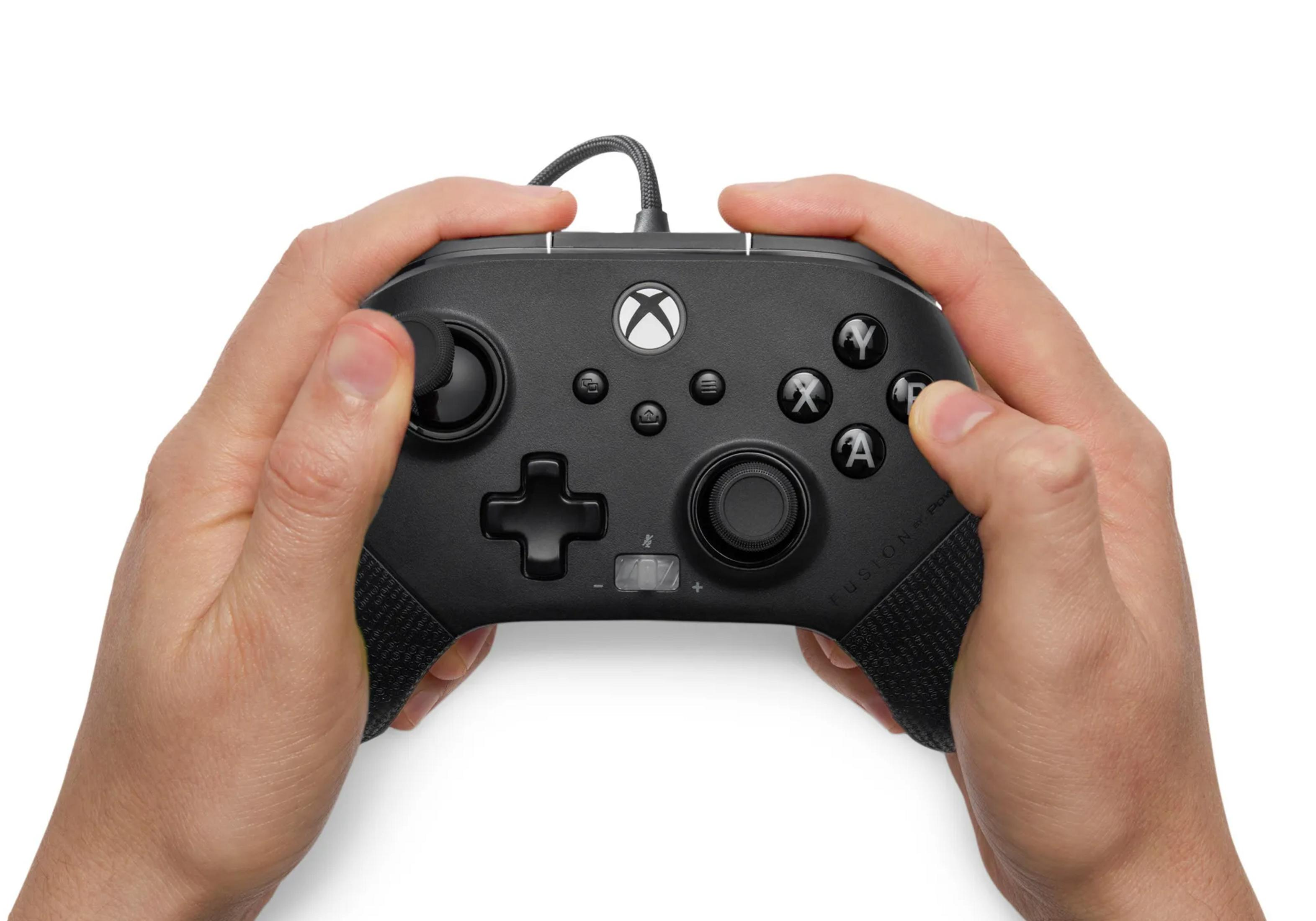 Dłonie trzymające czarny kontroler Xbox z kablem.