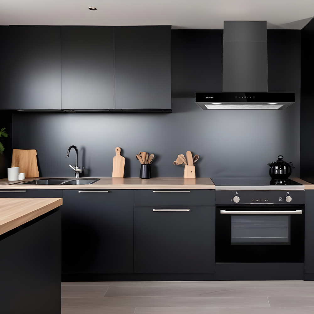 Moderna cocina negra con encimeras de madera, fregadero, estufa y campana.