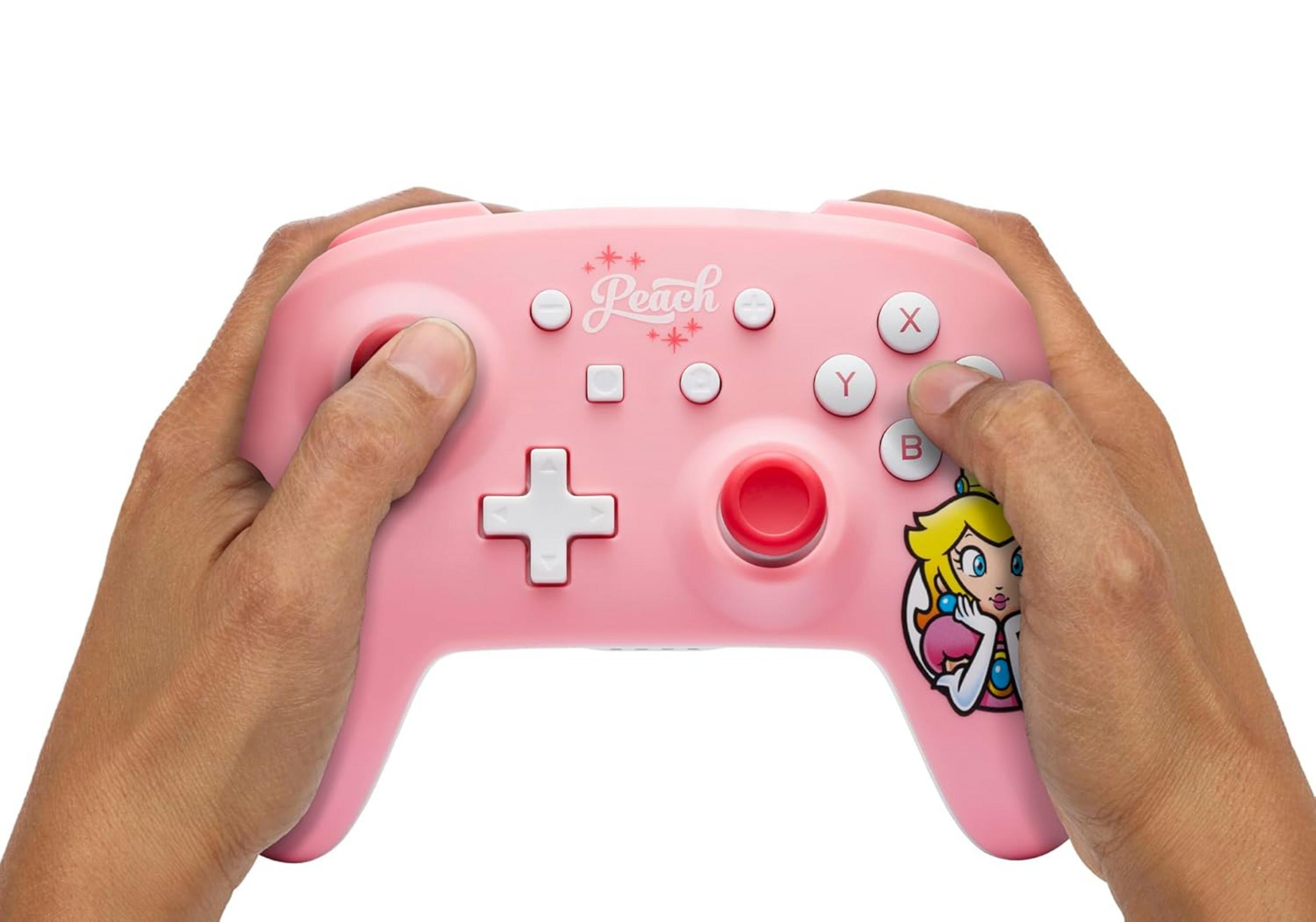 Hände halten eine rosa Nintendo Switch Controller mit Prinzessin Peach-Grafik.