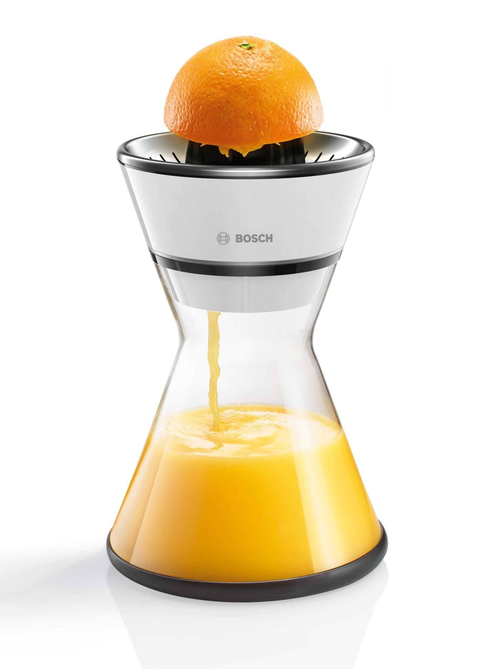 Un exprimidor de naranjas con media naranja encima y zumo en el recipiente de cristal.