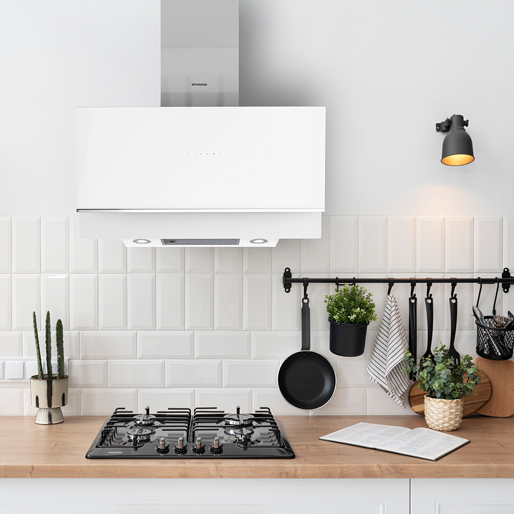 Cocina moderna con campana extractora blanca, cocina de gas y encimera de madera.
