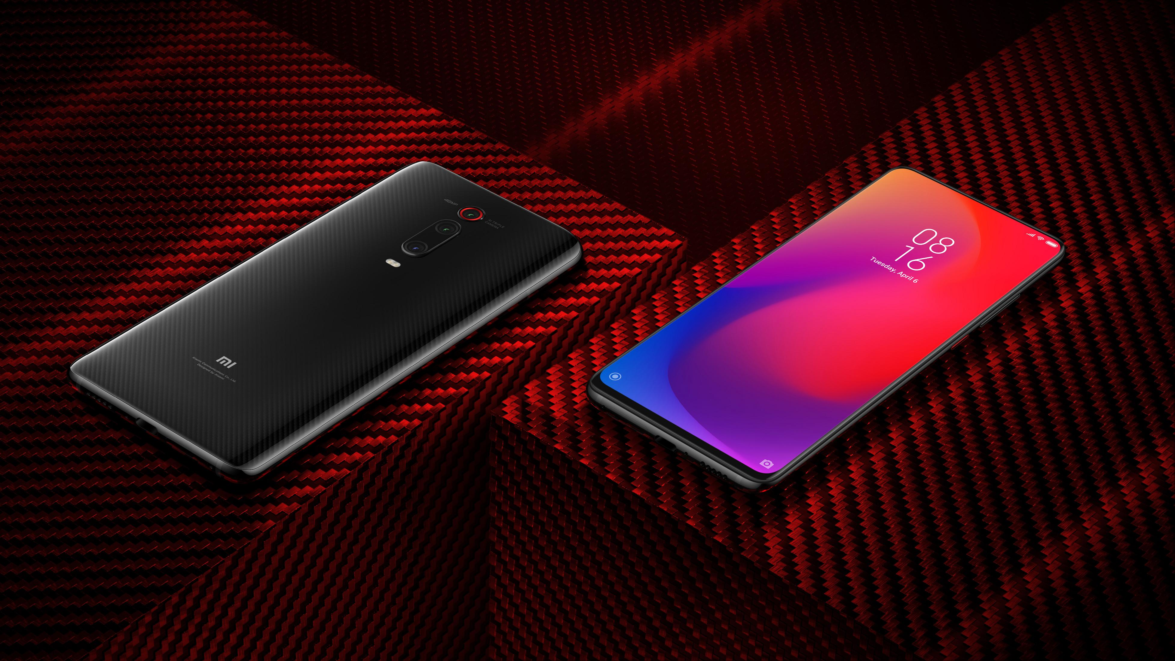 Schwarzes Smartphone mit Carbon-Finish auf rotem Carbon-Untergrund.