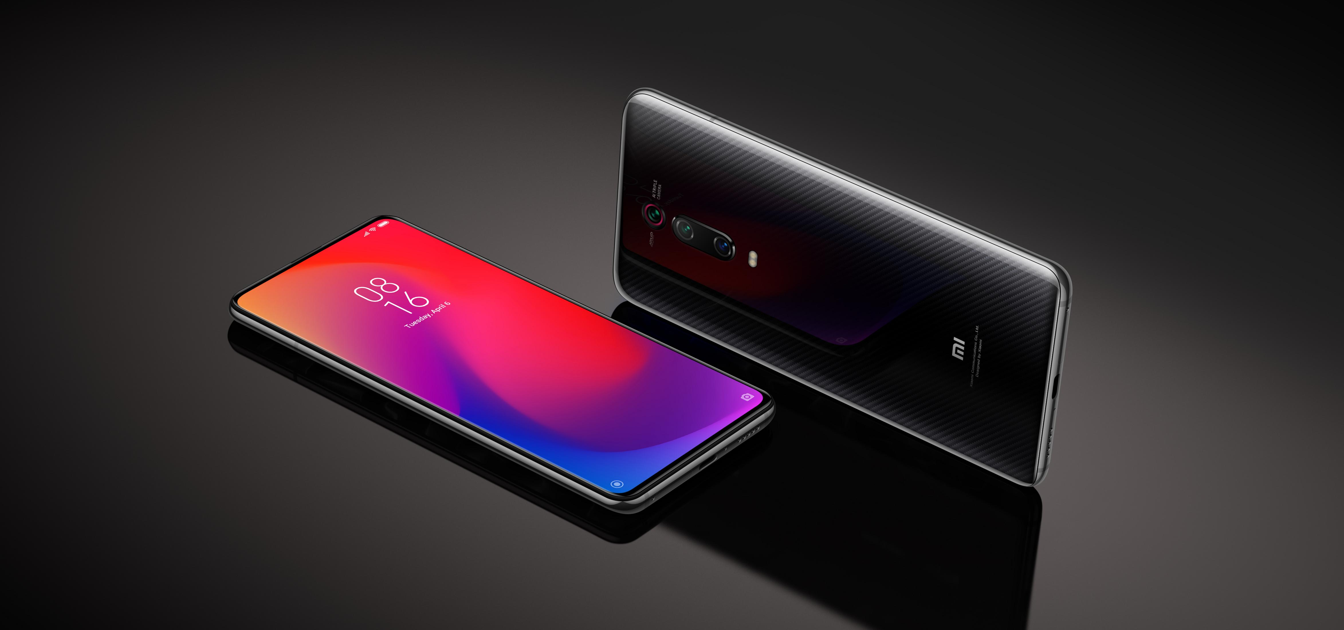 Zwei Smartphones liegen auf einer dunklen glatten Oberfläche. Eines zeigt den Bildschirm mit bunter Grafik.