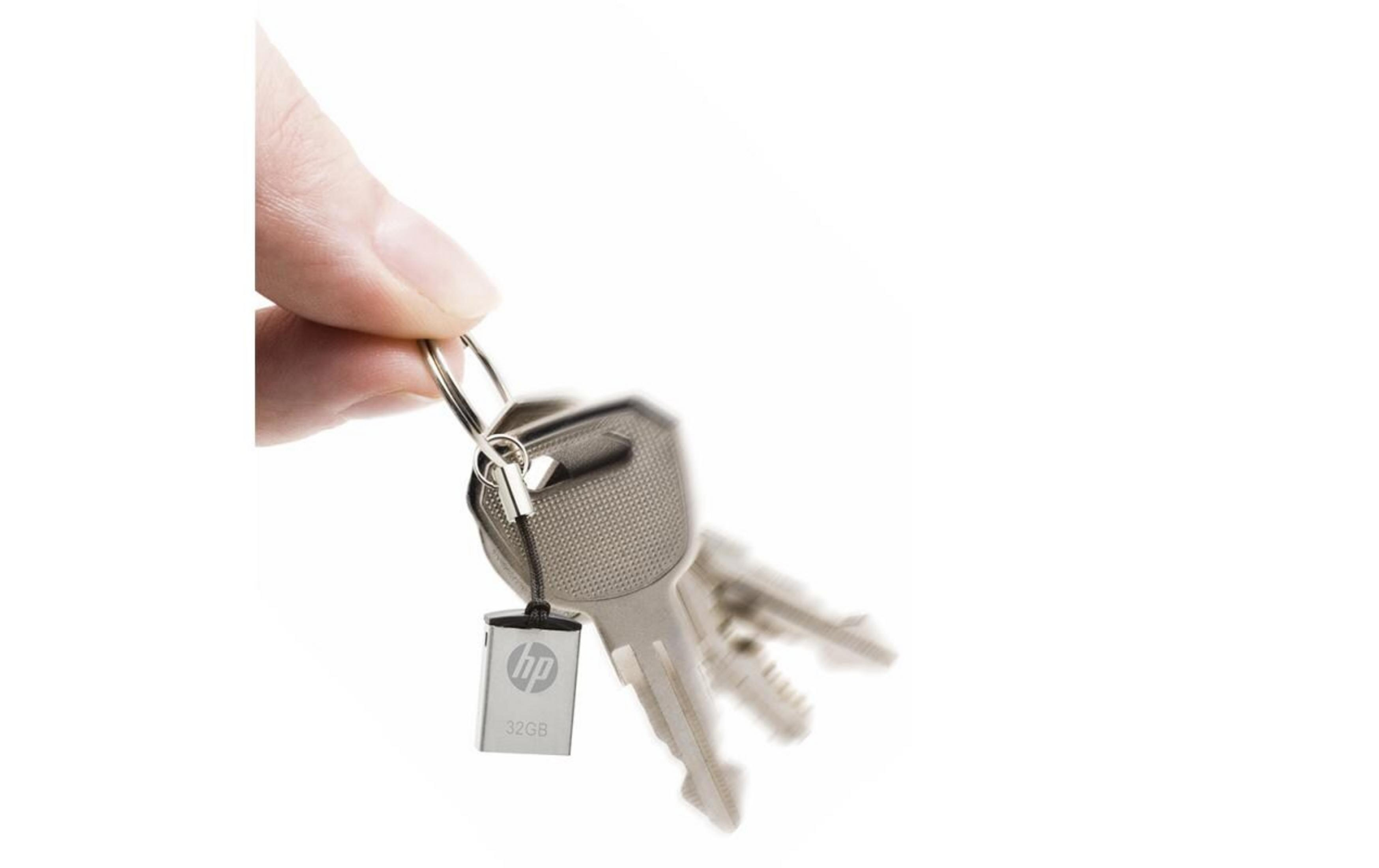 Ręka trzyma klucze ze srebrnym pendrivem HP.