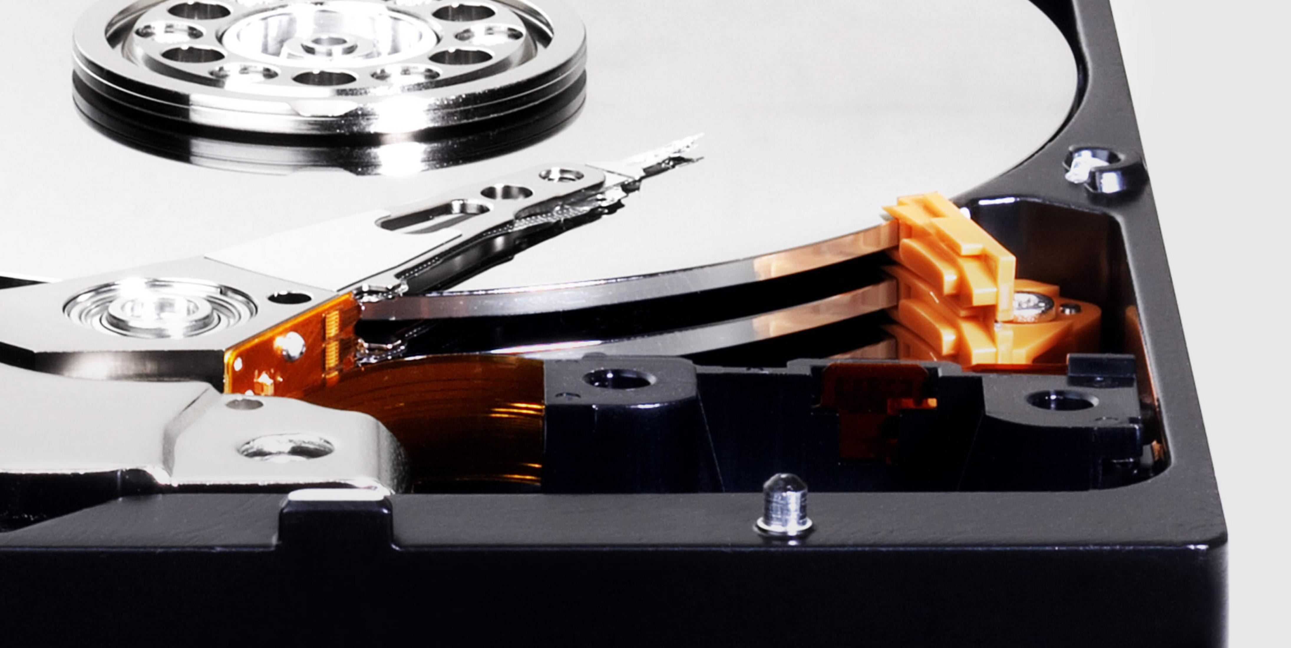 Close-up of an open hard drive, showing silver platters and a read/write head.