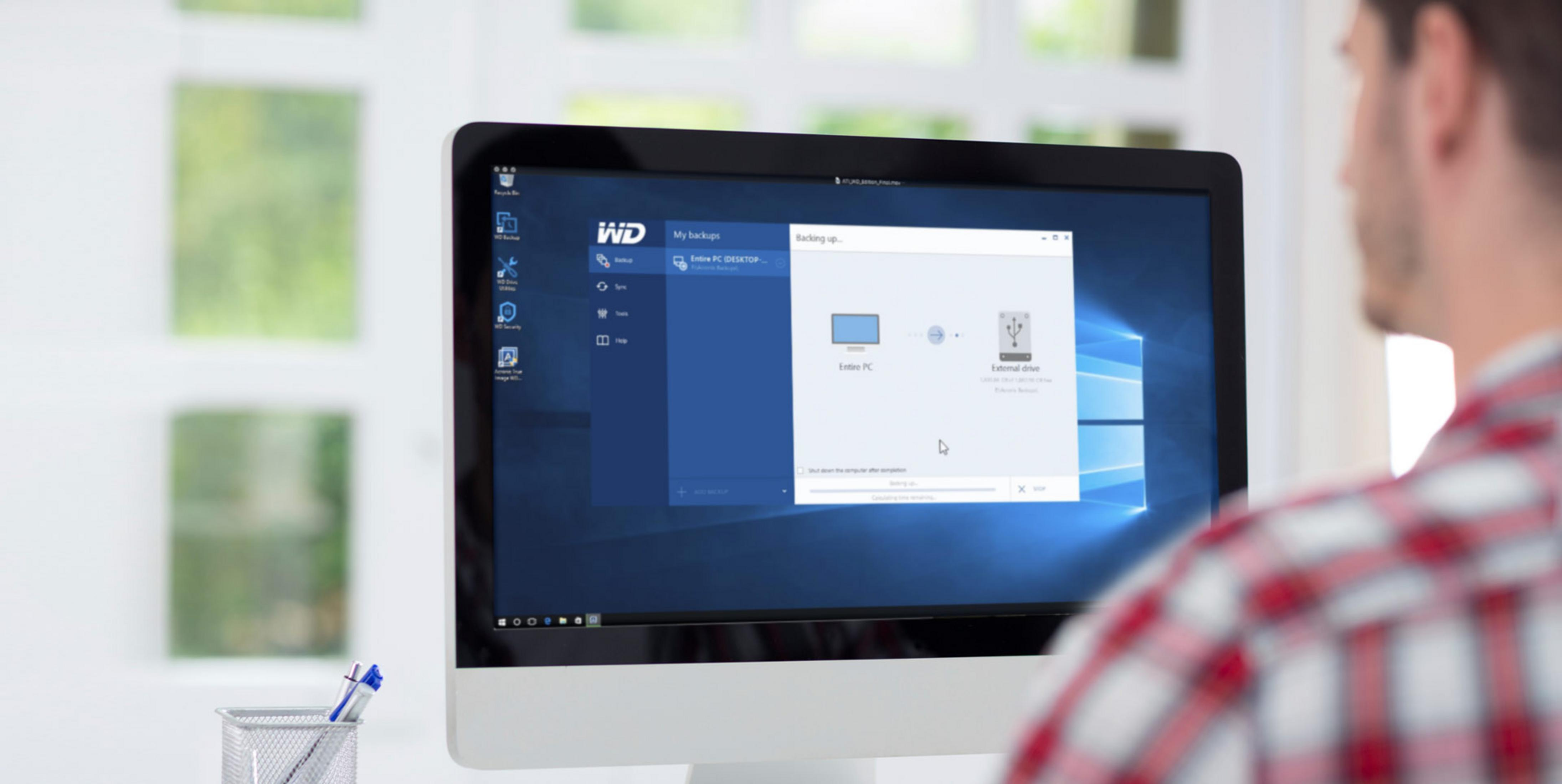 Man backs up entire PC to external drive on a desktop computer.