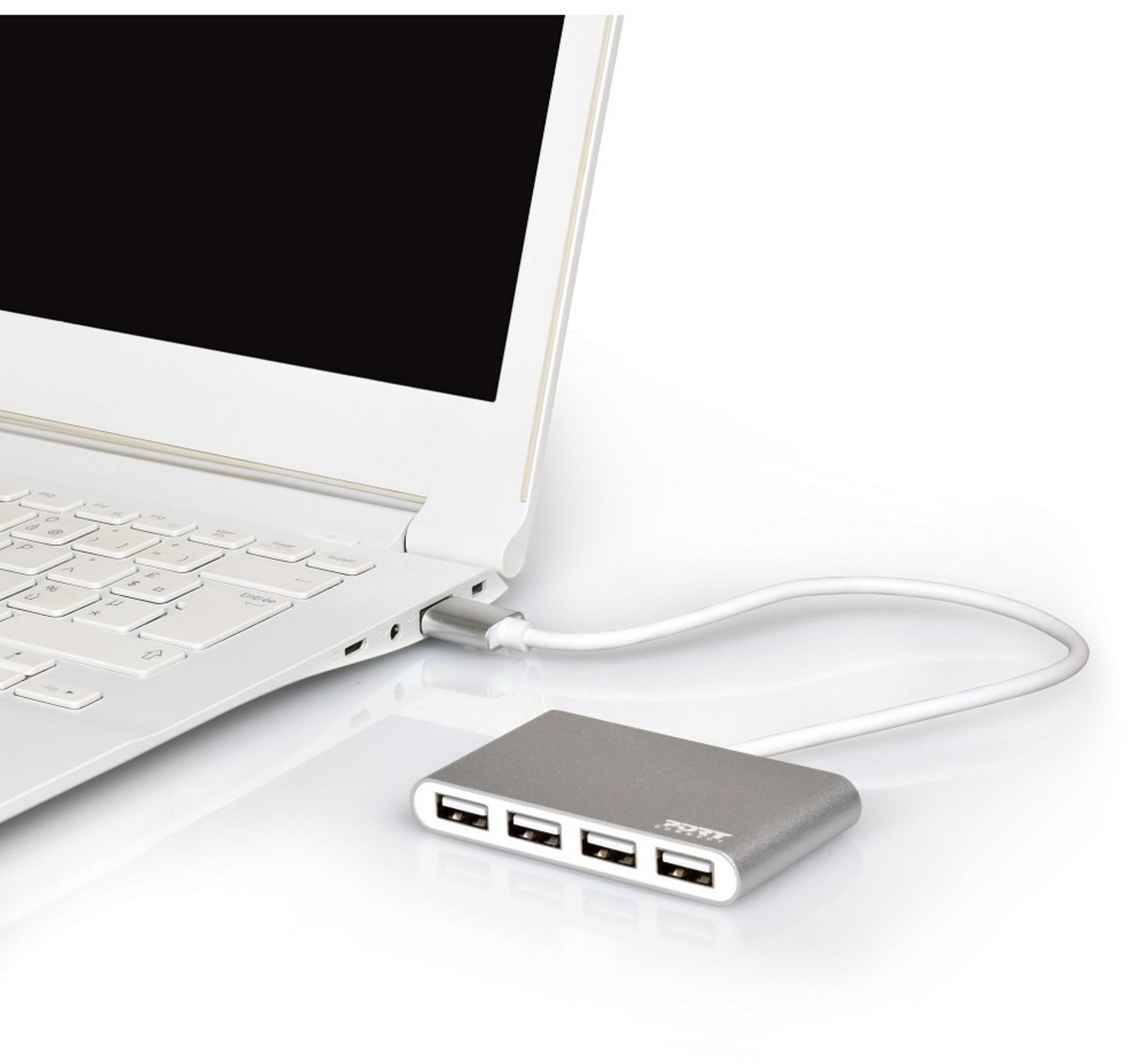 Un hub USB argentato è collegato a un laptop bianco. L'hub ha quattro porte USB.