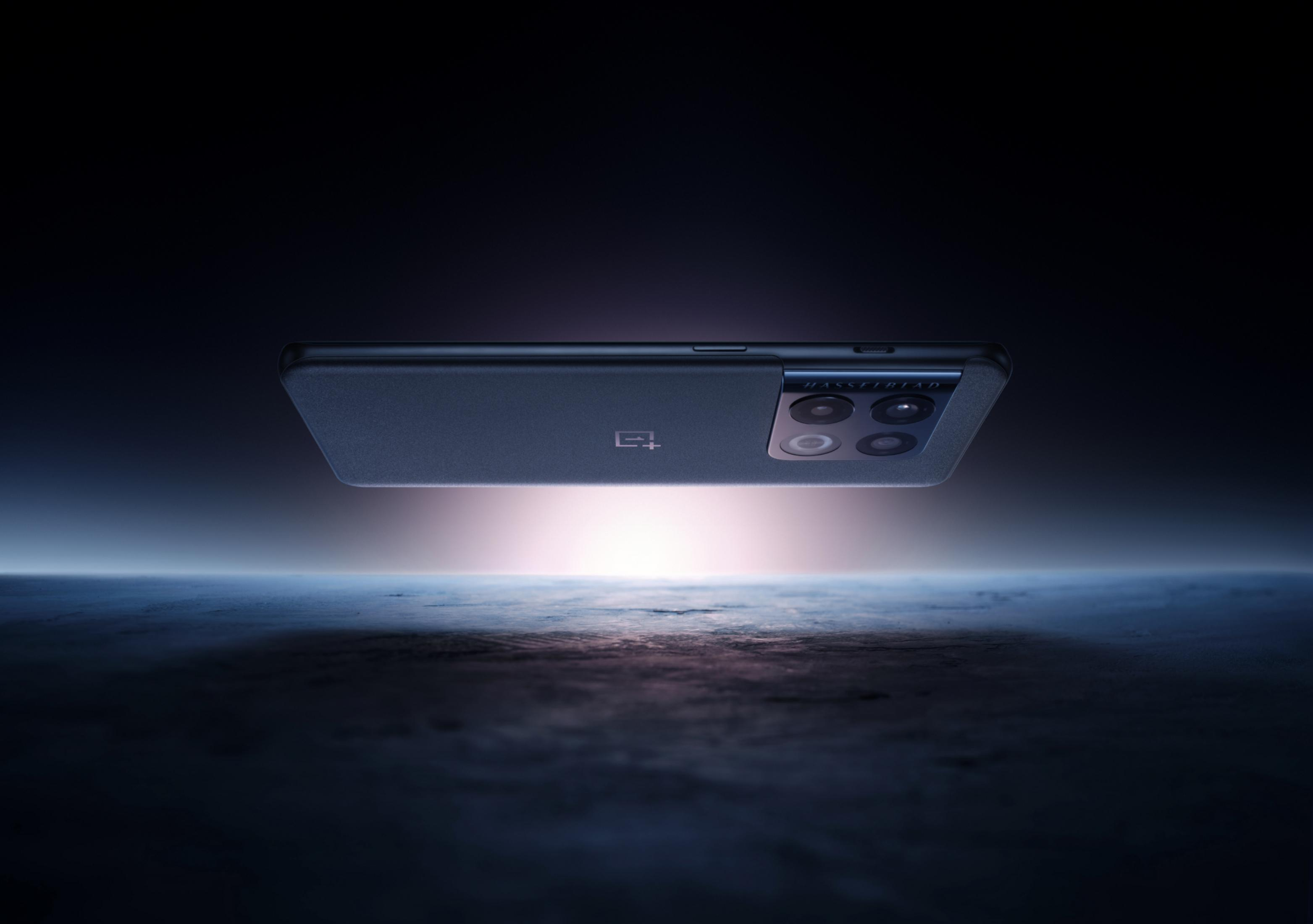 Ciemny smartfon z czterema aparatami unosi się nad oświetloną ziemią.