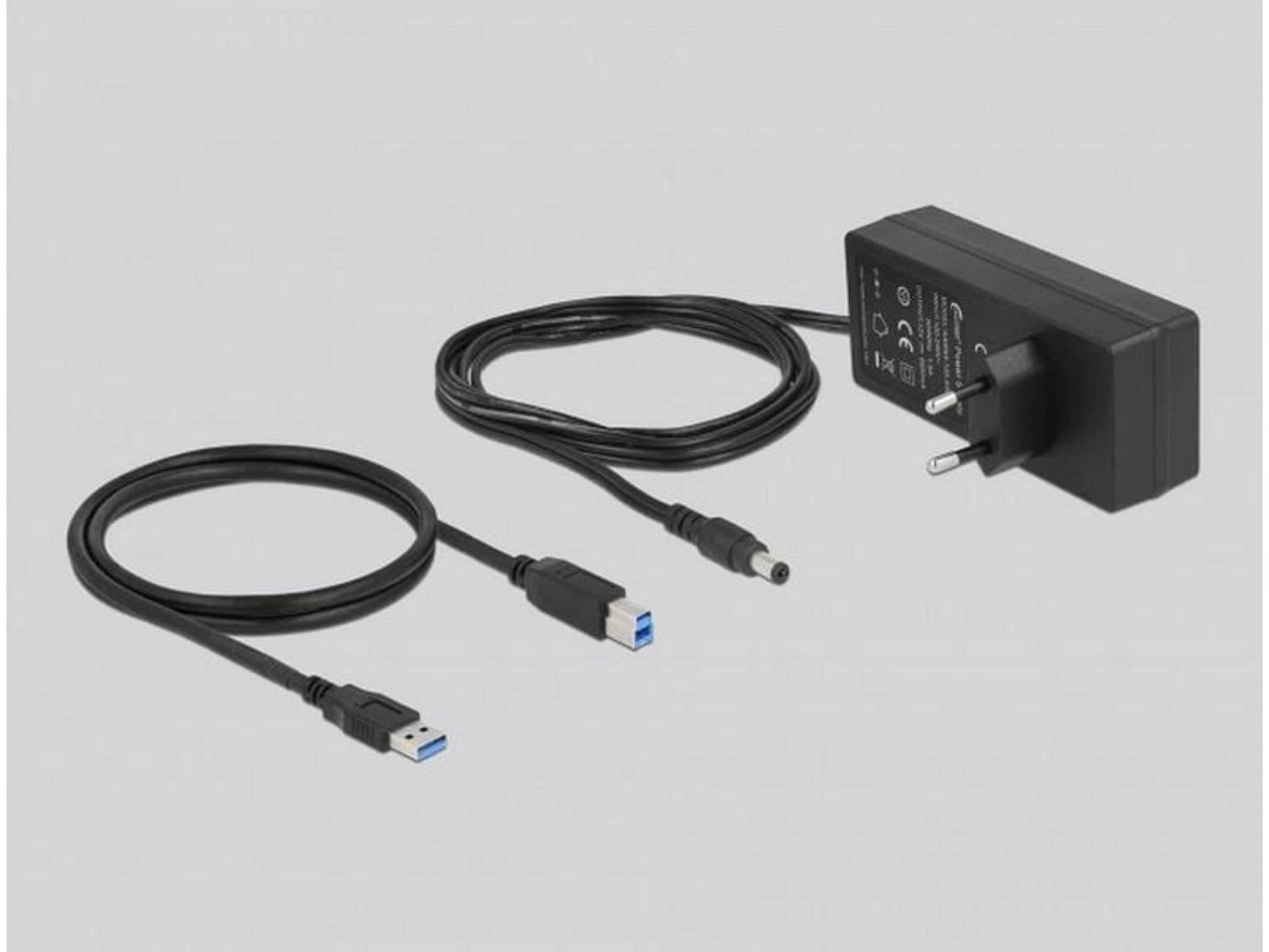 Schwarzes Netzteil mit USB-Kabel und rundem Stecker auf grauem Hintergrund.