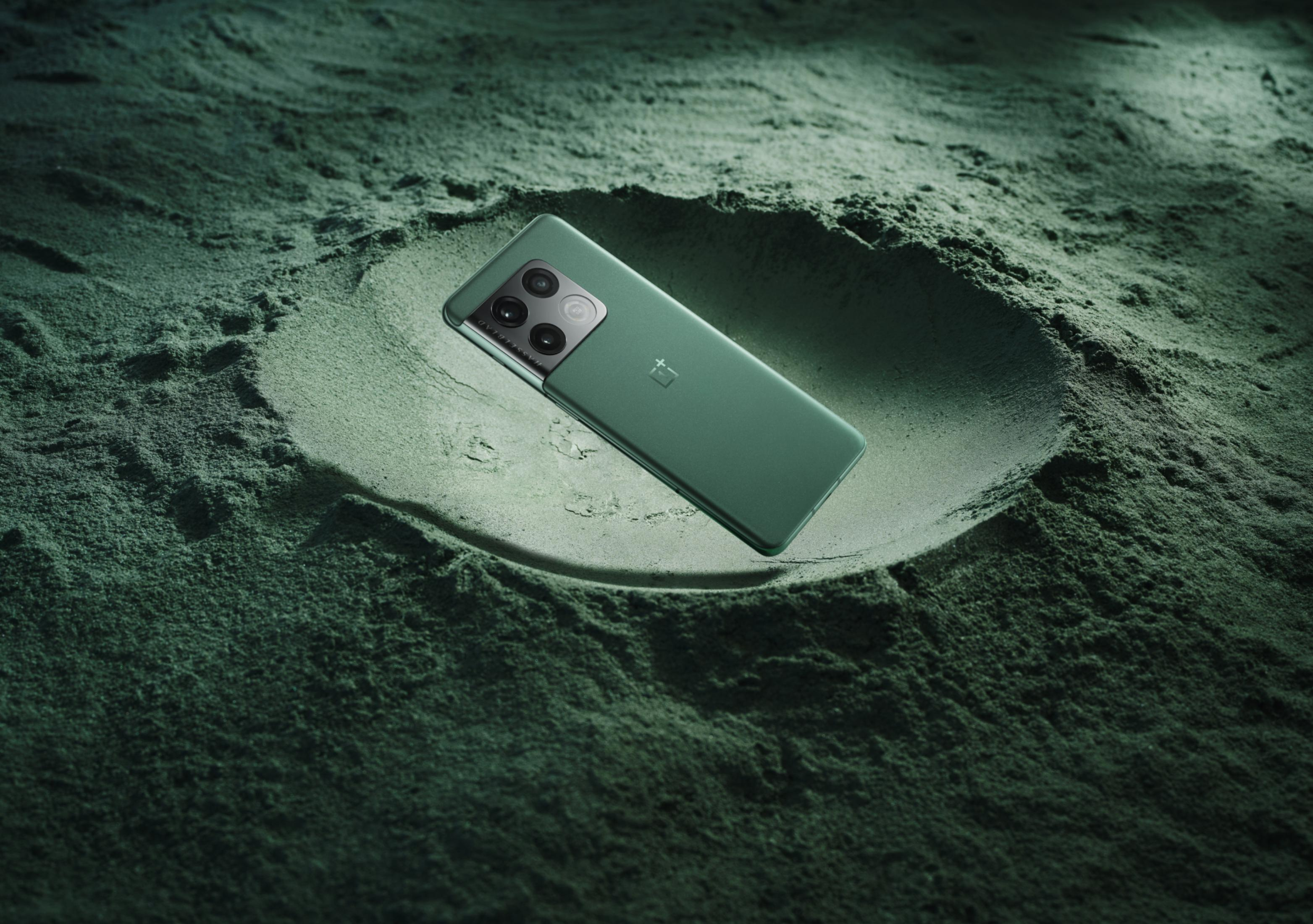 Ein grünes Smartphone liegt in einer kreisförmigen Vertiefung aus grünem Pulver.