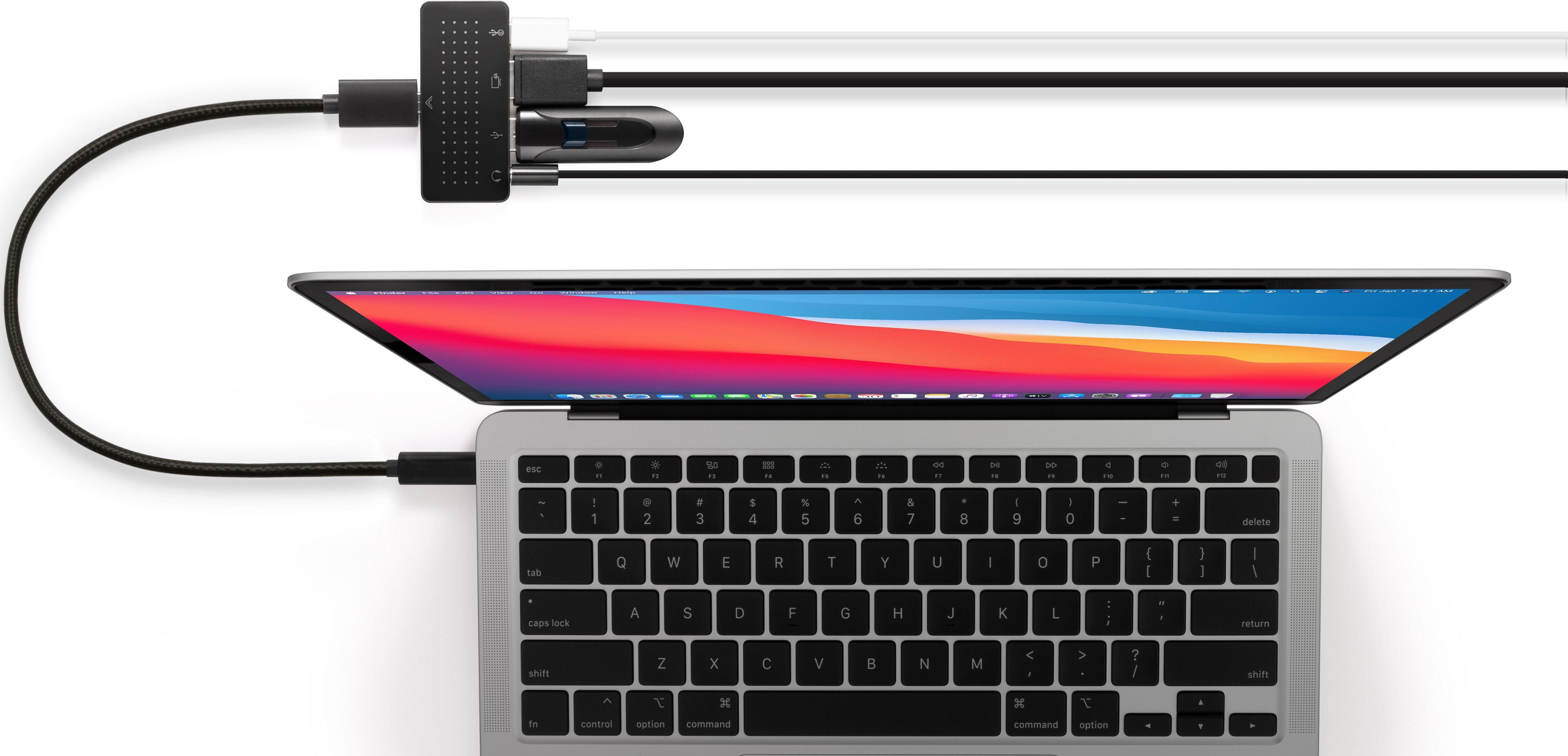Un laptop moderno con hub USB-C e cavi collegati su sfondo bianco.