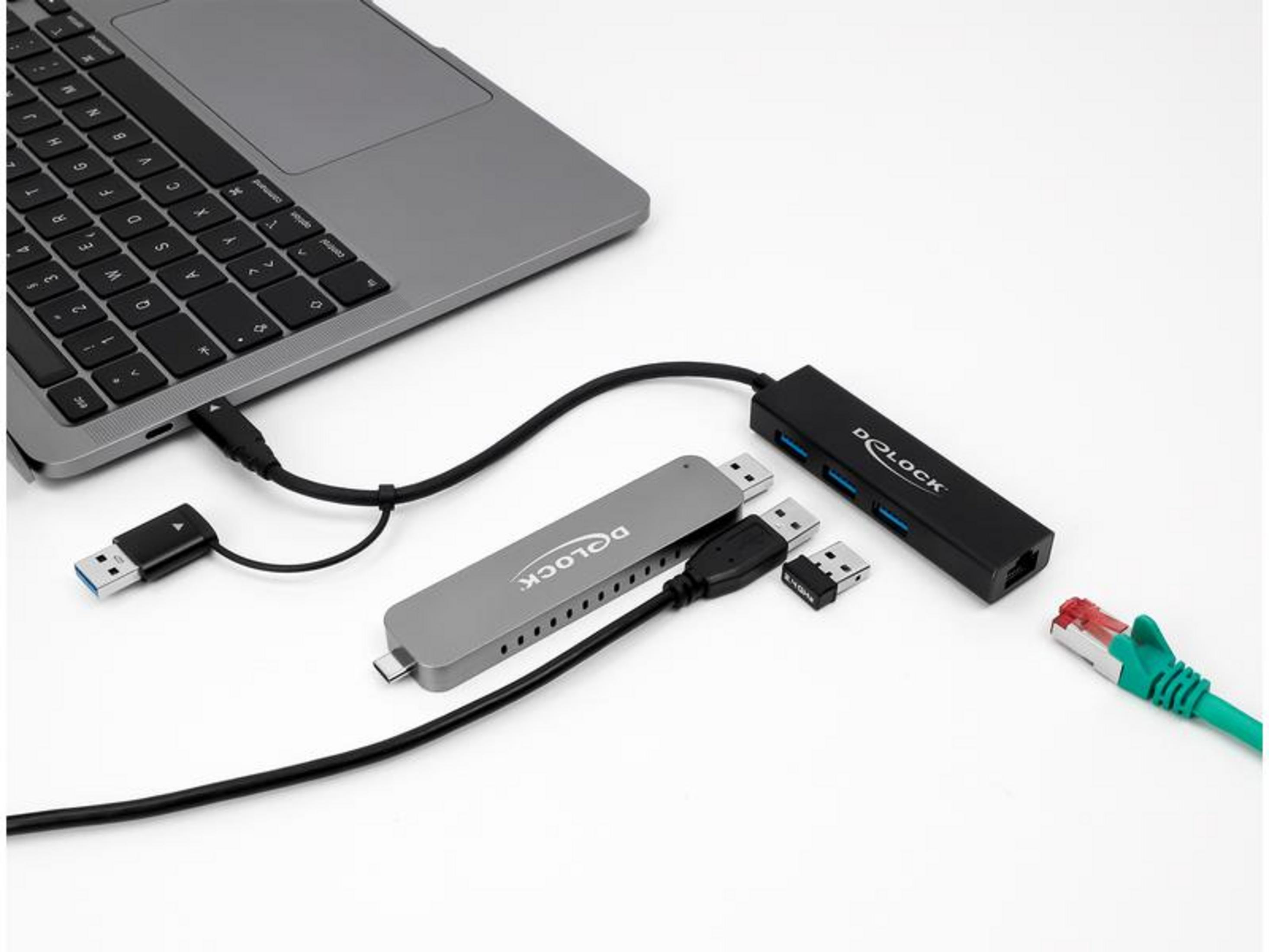 Laptop con hub USB-C, cavo Ethernet e chiavette USB su sfondo bianco.