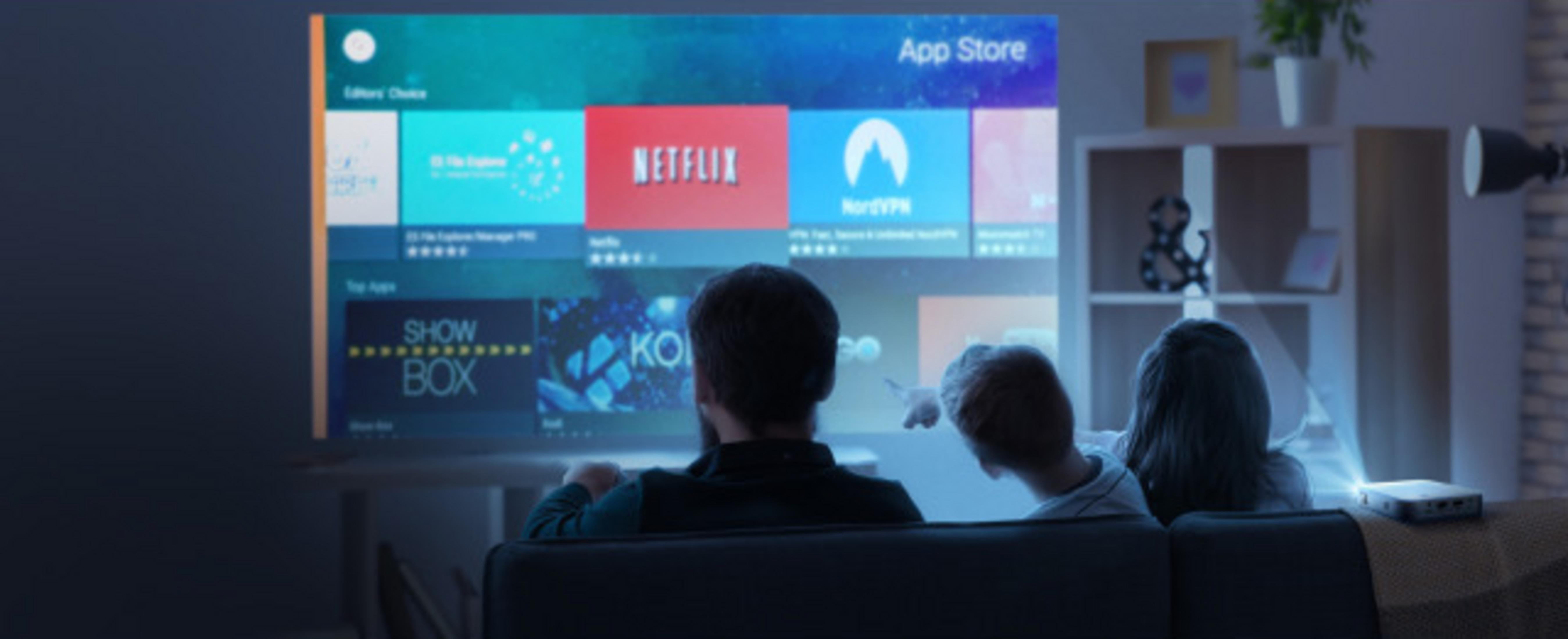Famille regardant un écran affichant des icônes d'applications : Netflix, Showbox et NordVPN.