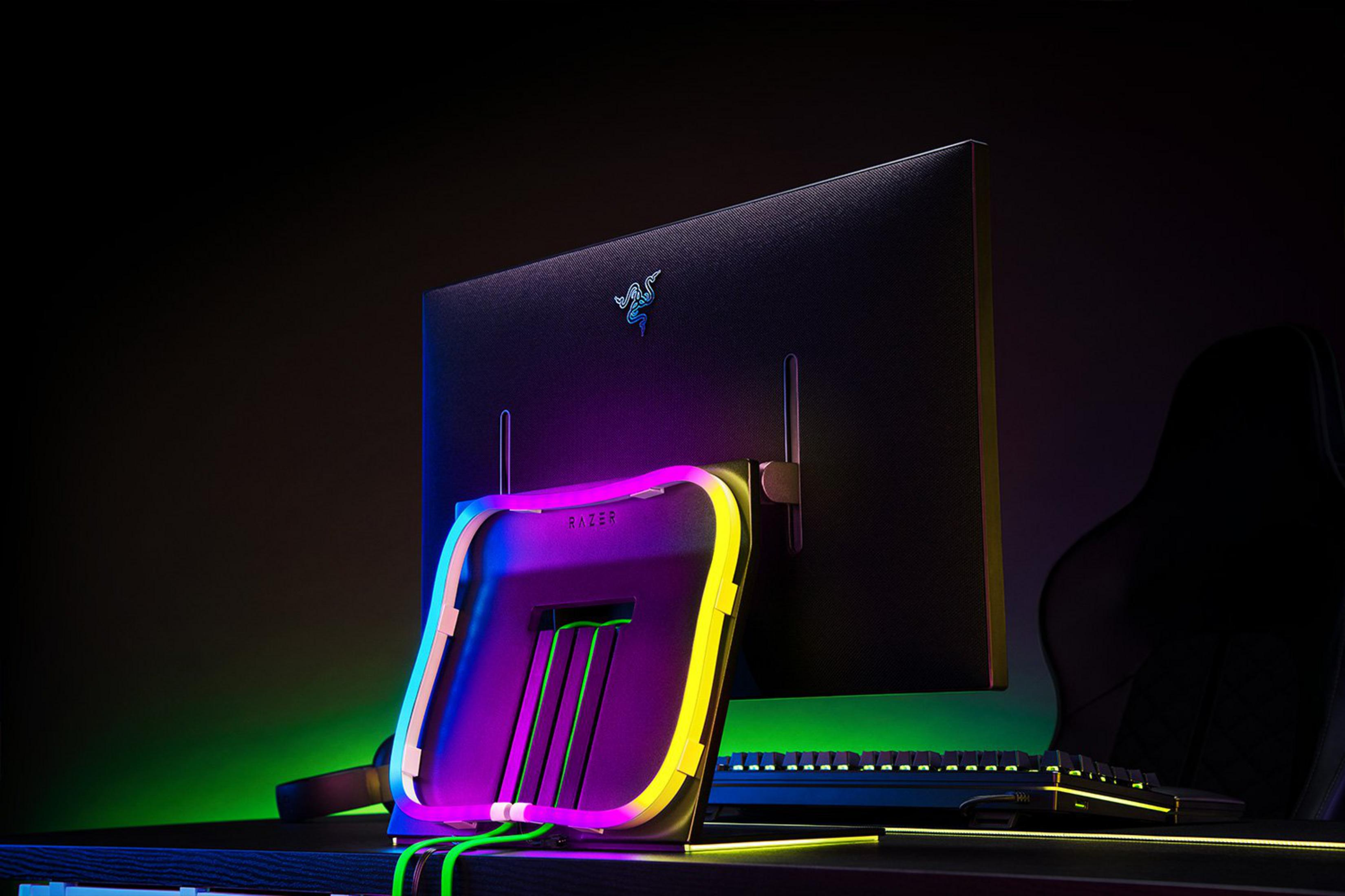 Ein Gaming-Setup mit Razer-Monitor, Tastatur, Stuhl und beleuchtetem Ständer.