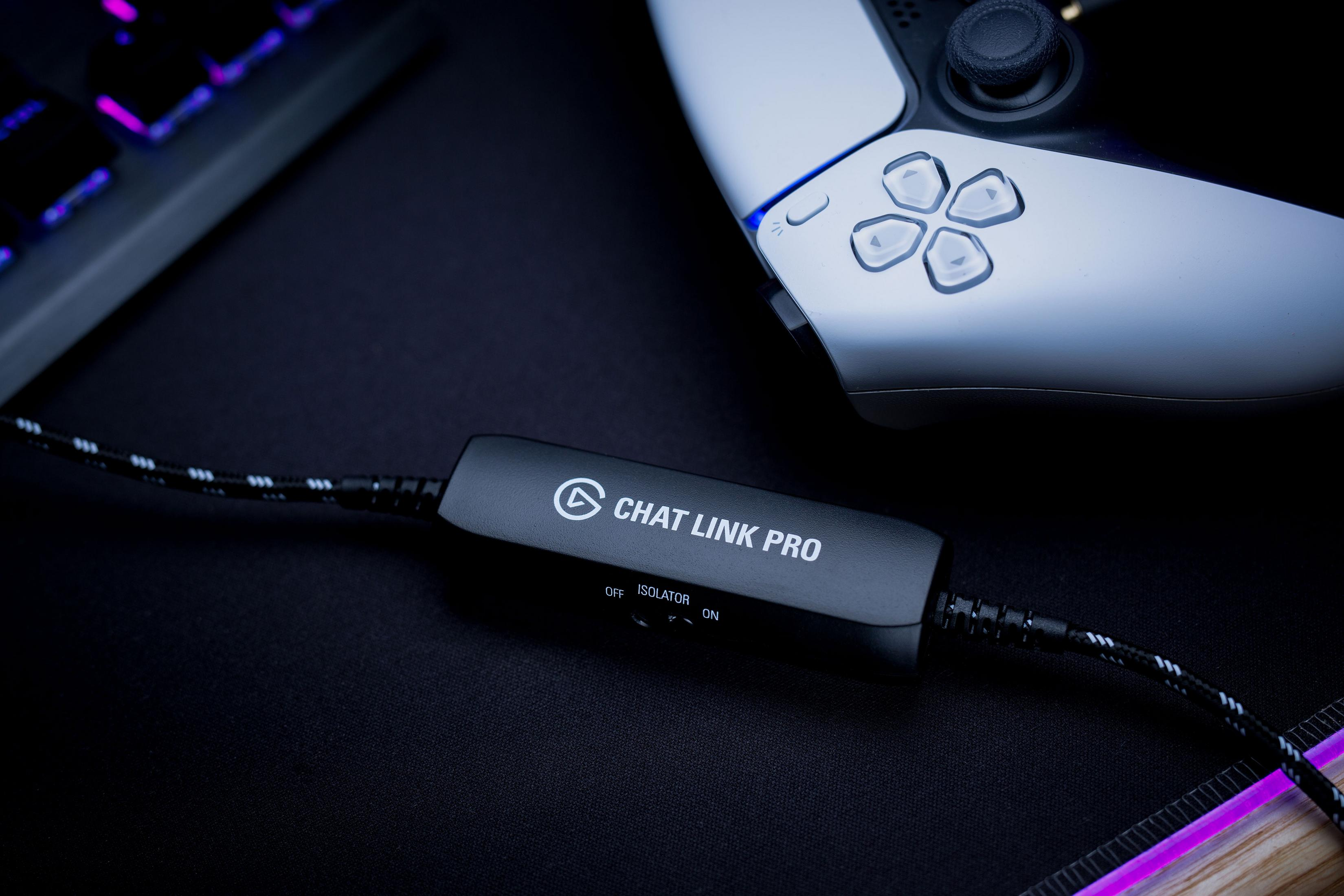 Un dispositivo Elgato Chat Link Pro nero riposa su un tappetino nero accanto a un controller di gioco bianco.