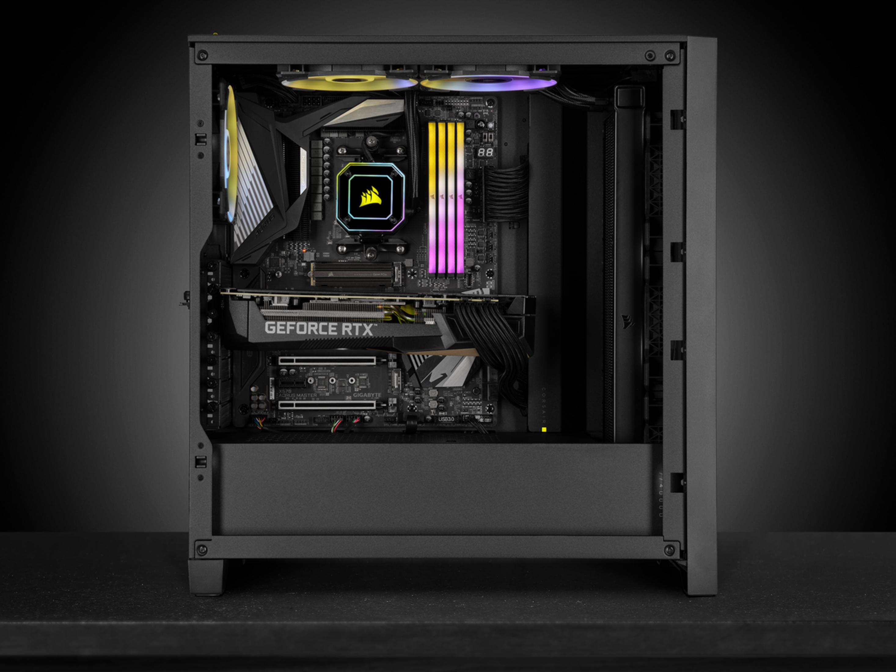 Otwarta obudowa komputera z podświetleniem RGB, kablami i podzespołami.