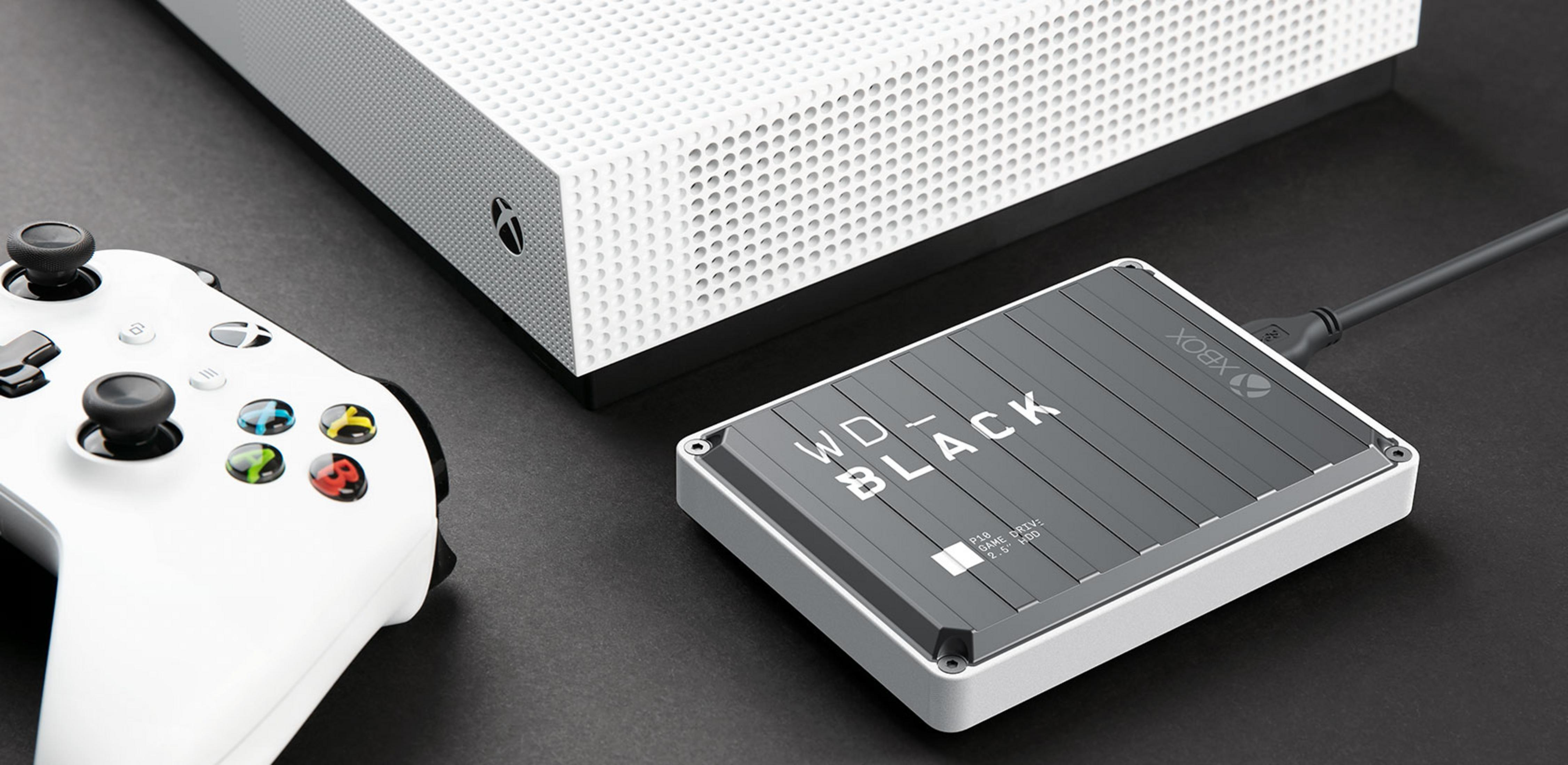 Biały kontroler Xbox, biała konsola Xbox i zewnętrzny dysk twardy na ciemnej powierzchni.
