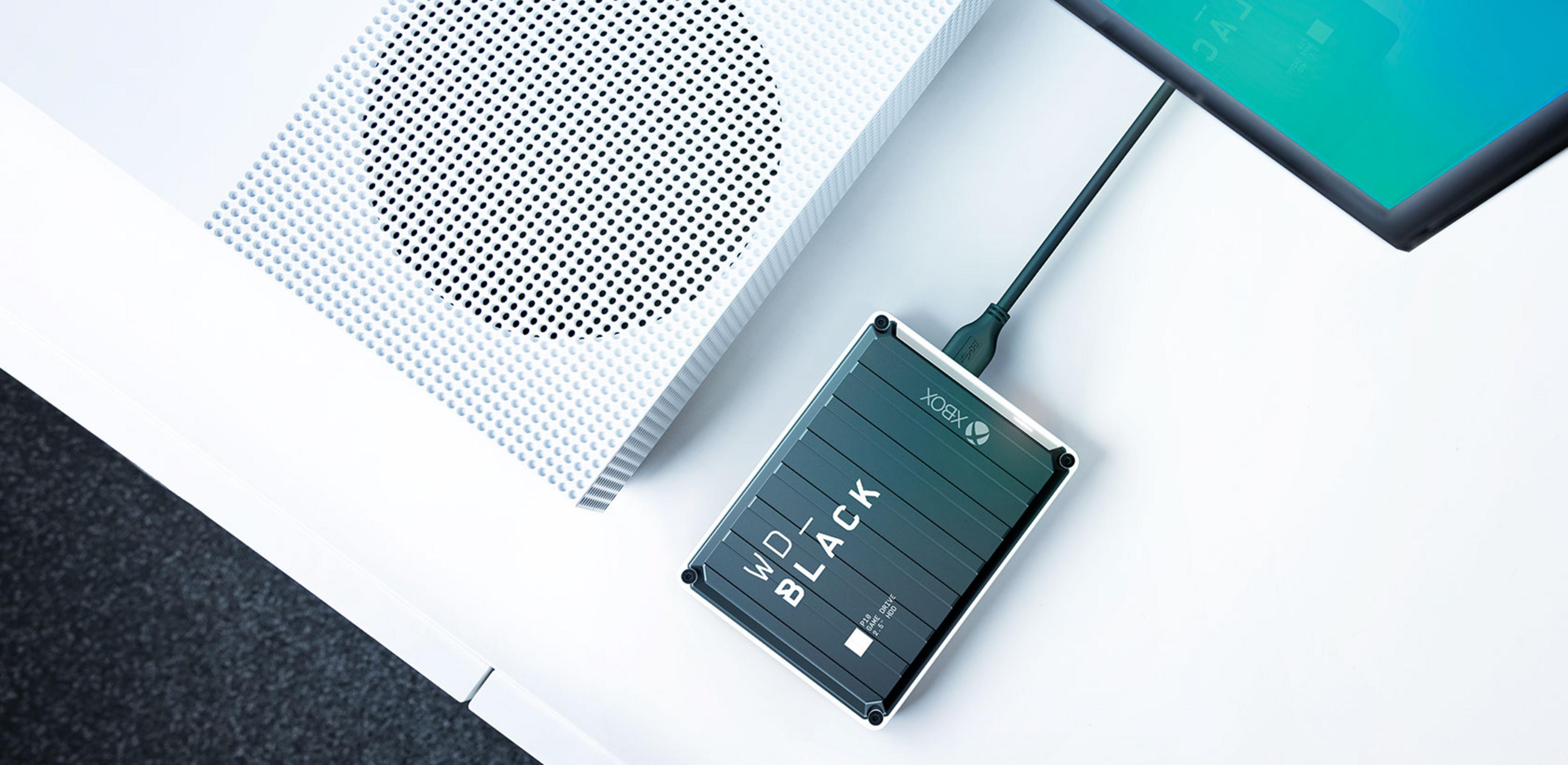 Biała konsola Xbox z podłączonym czarnym dyskiem zewnętrznym.