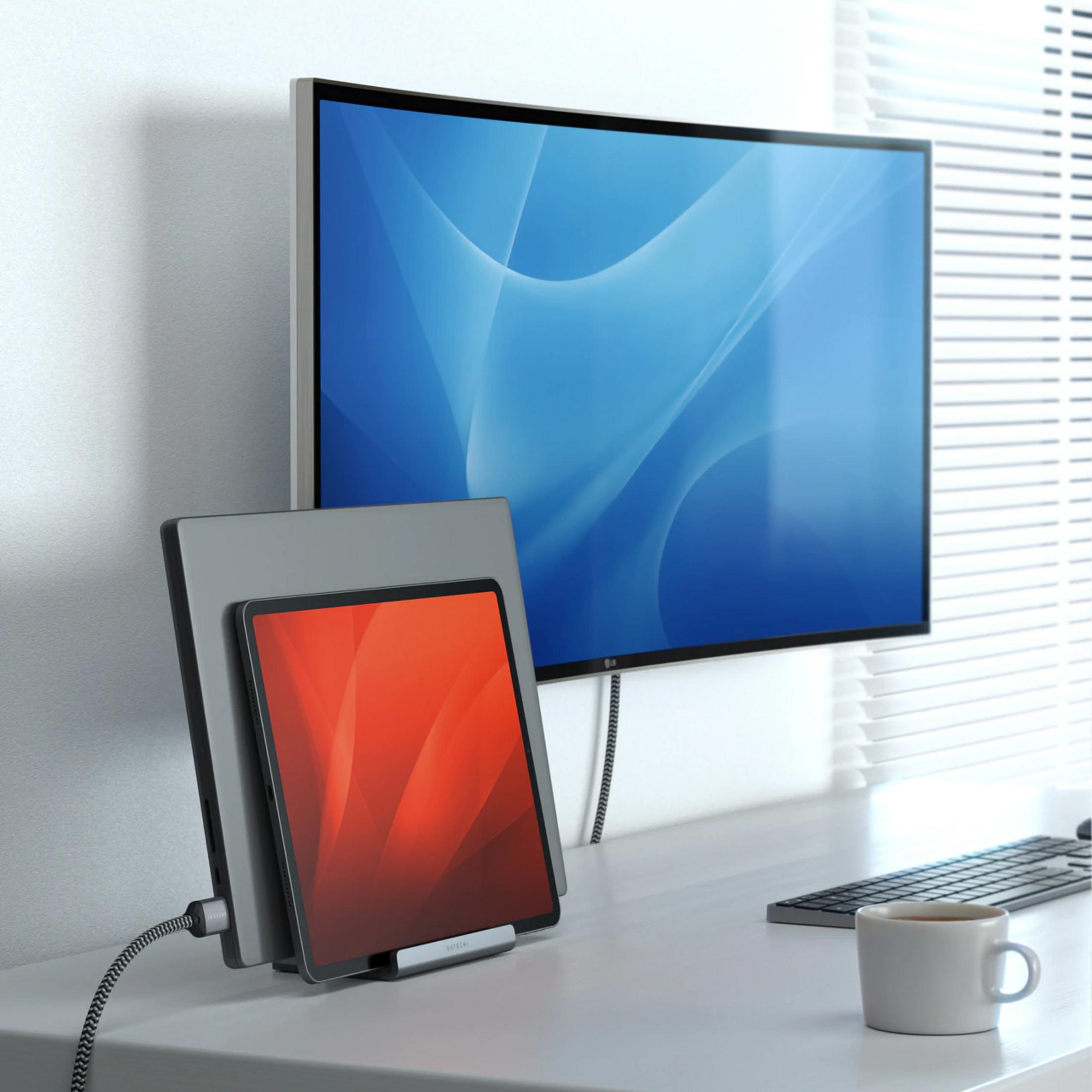 Una scrivania con un monitor, un tablet e una tastiera.