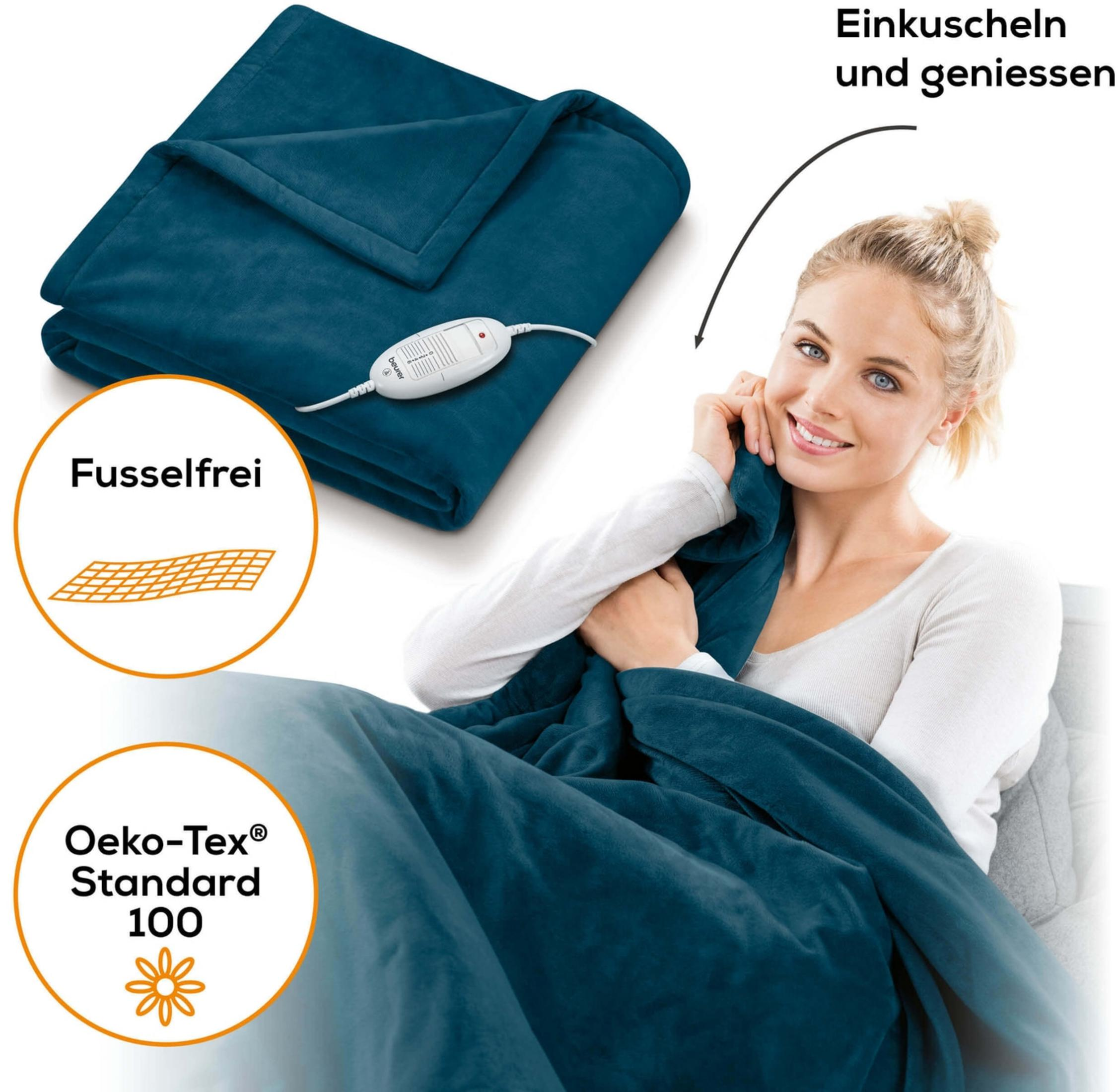 Donna si gode una coperta riscaldata blu con telecomando. Senza pelucchi e certificata Oeko-Tex.