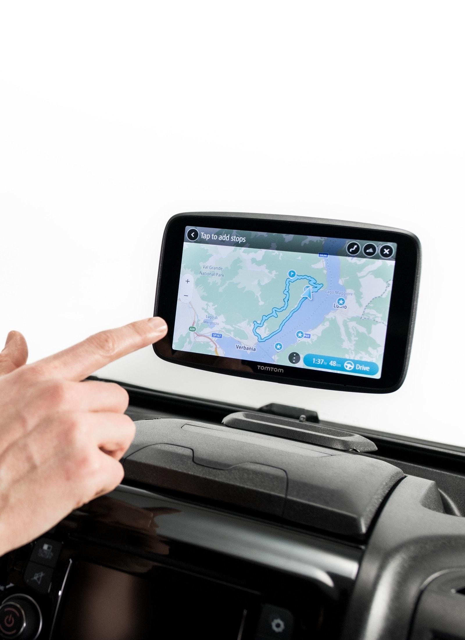 Ein Finger tippt auf ein Navigationsgerät mit einer Karte und einer Route.
