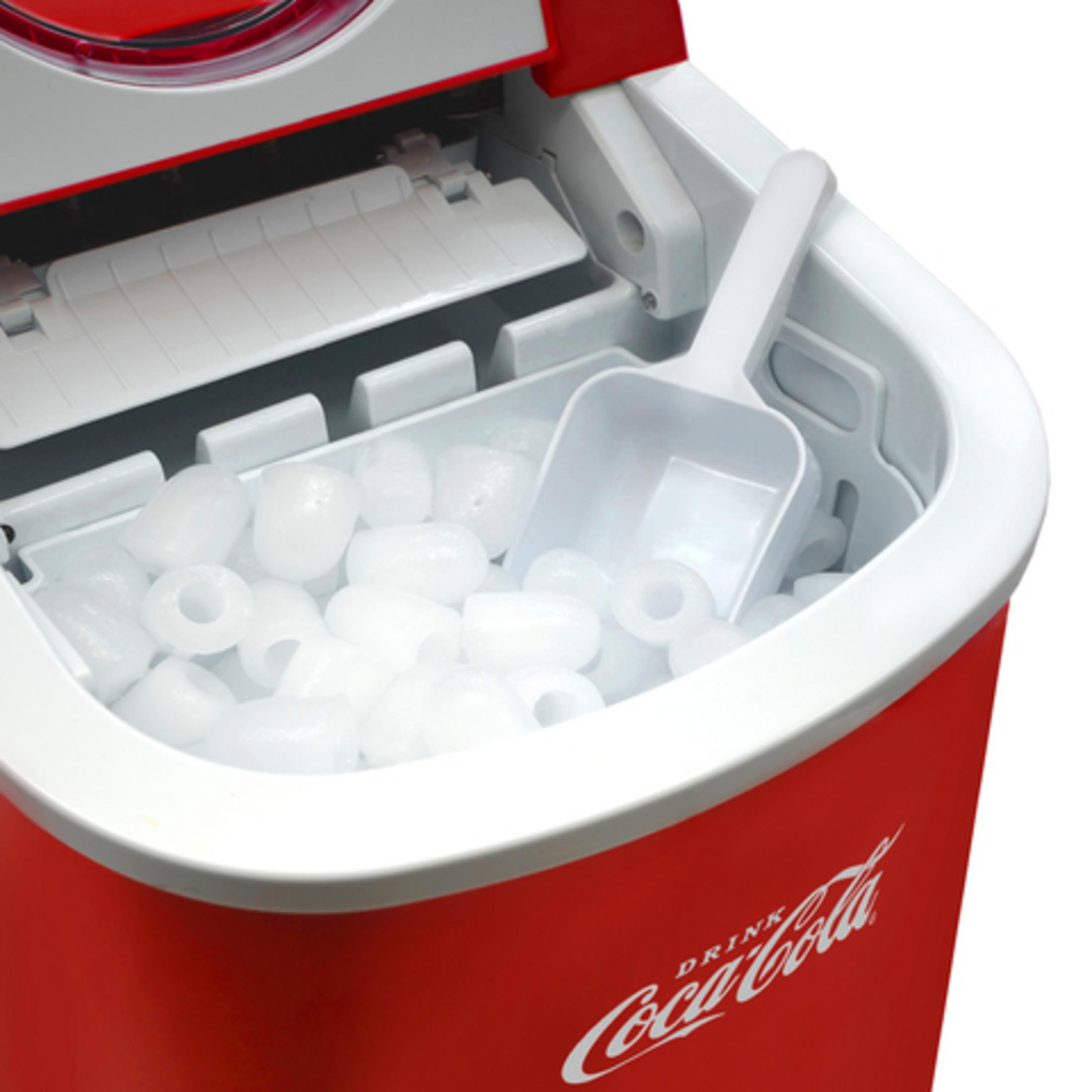 Una macchina del ghiaccio rossa Coca-Cola con paletta bianca e molti cubetti.