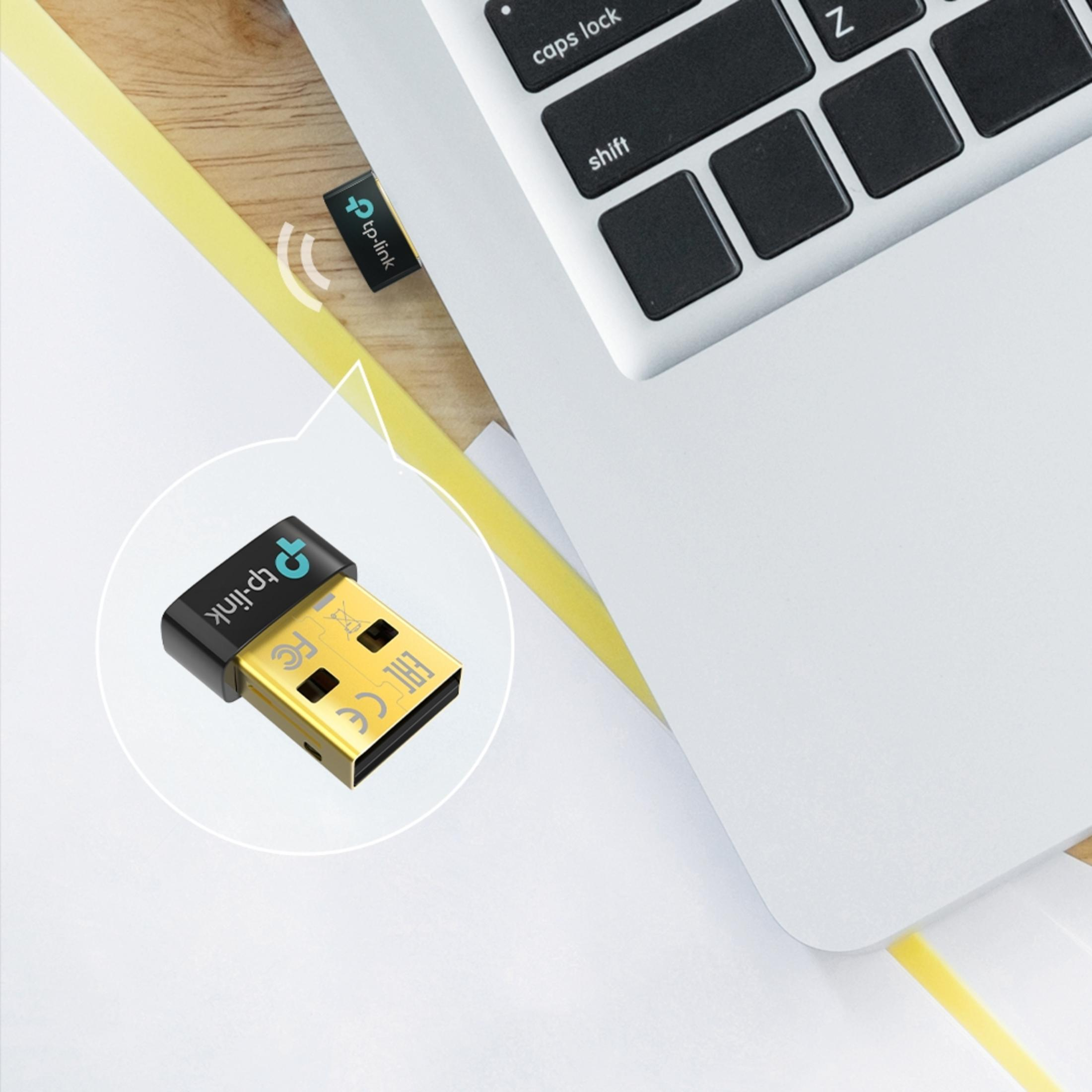 Un piccolo adattatore USB nero TP-Link è collegato a un laptop.