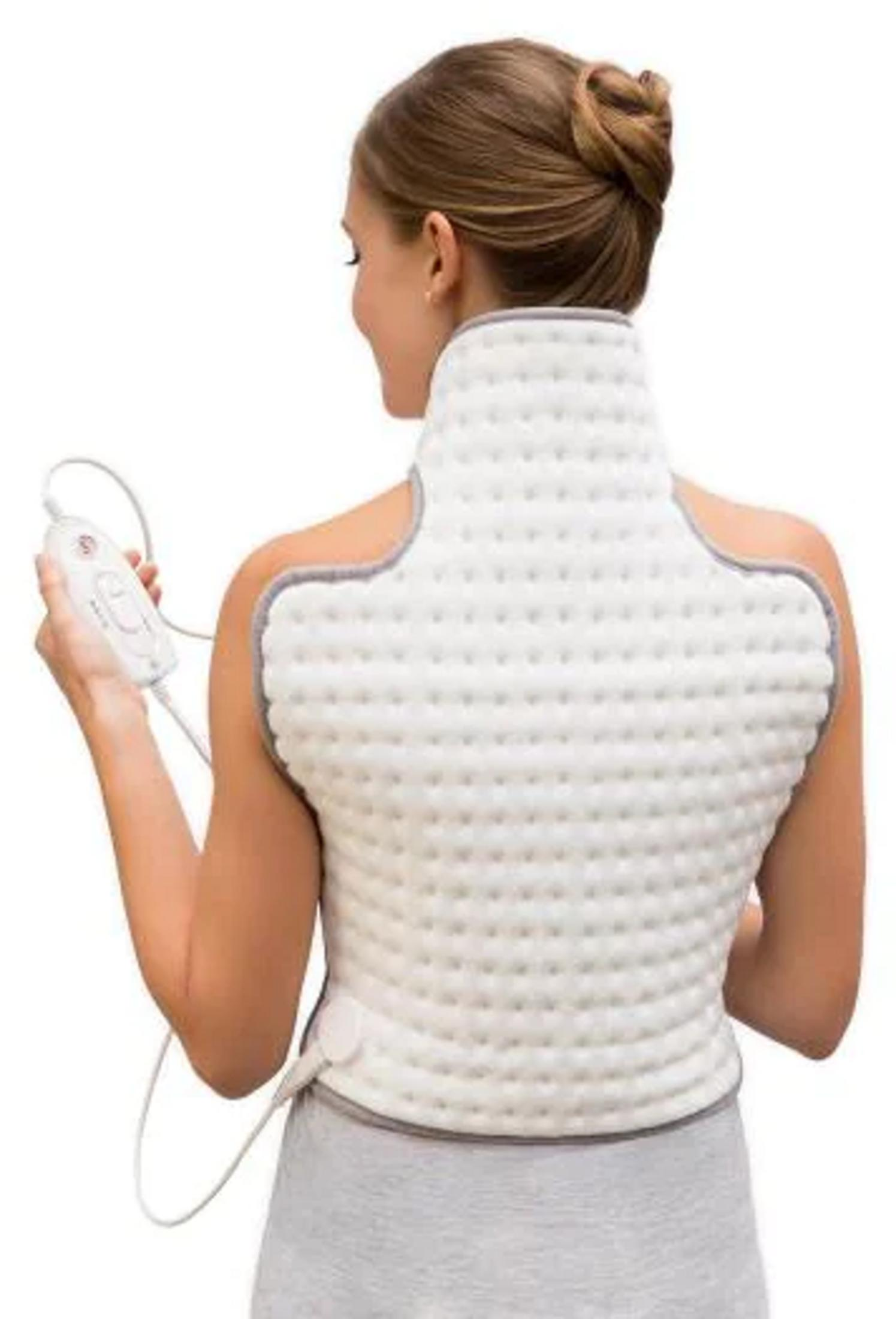 Kobieta nosi białą kamizelkę grzewczą z szarym wykończeniem i trzyma kontroler.