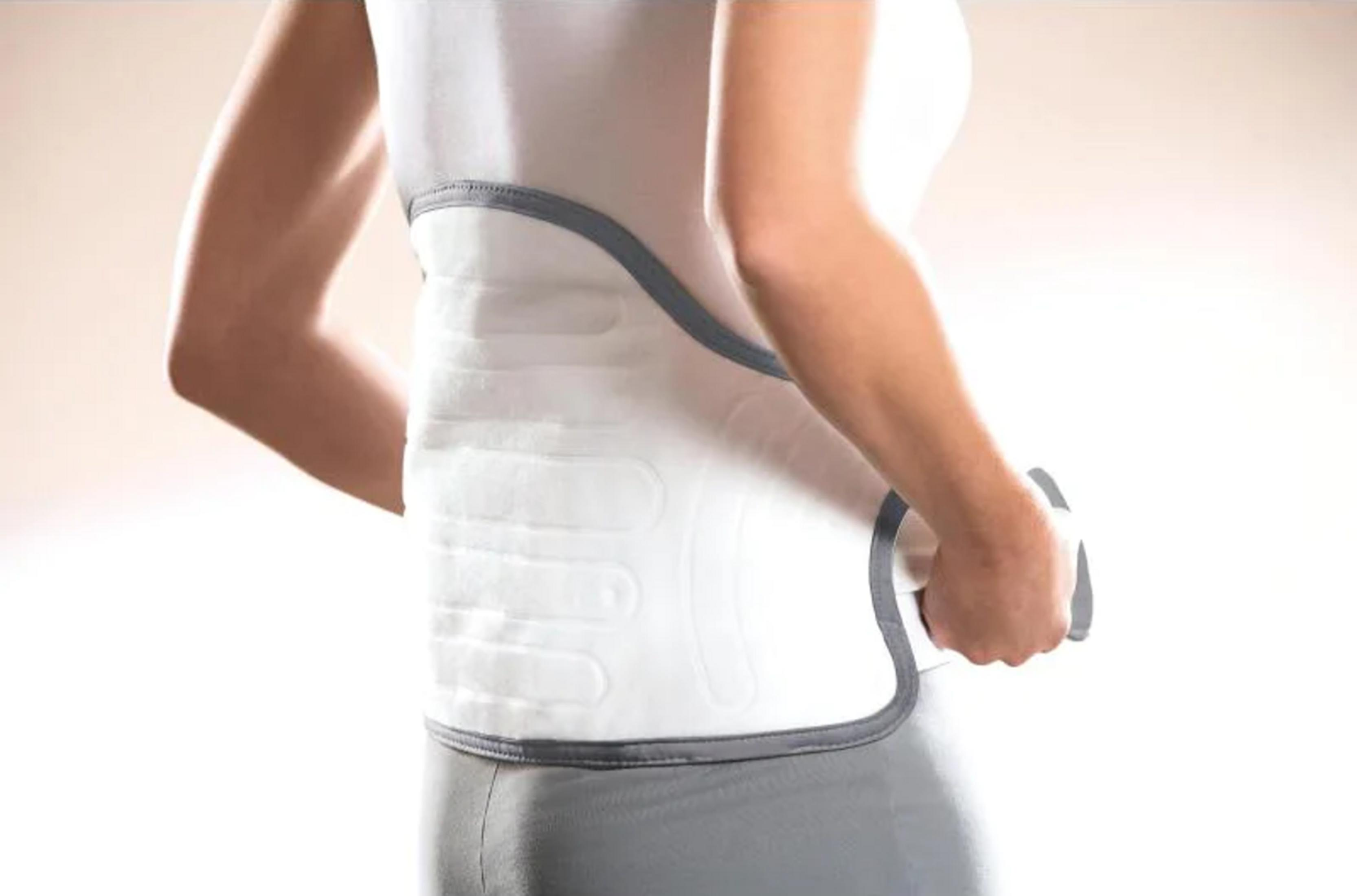 Osoba nosi biały gorset ortopedyczny z szarym wykończeniem. Widoczne ramię.