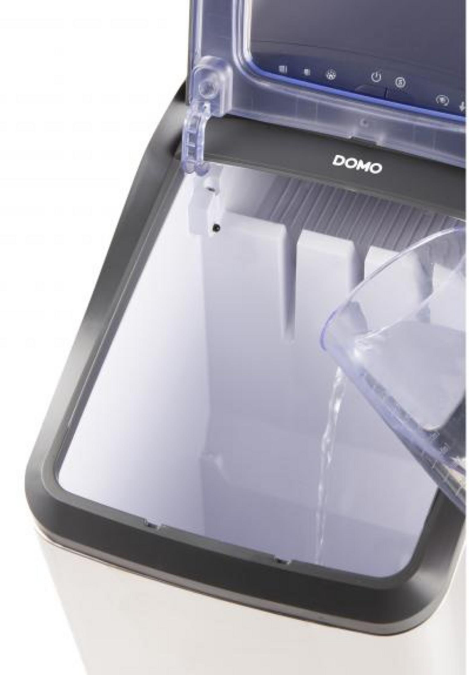 Woda wlewana do kostkarki. Przezroczysty dzbanek, biała maszyna.