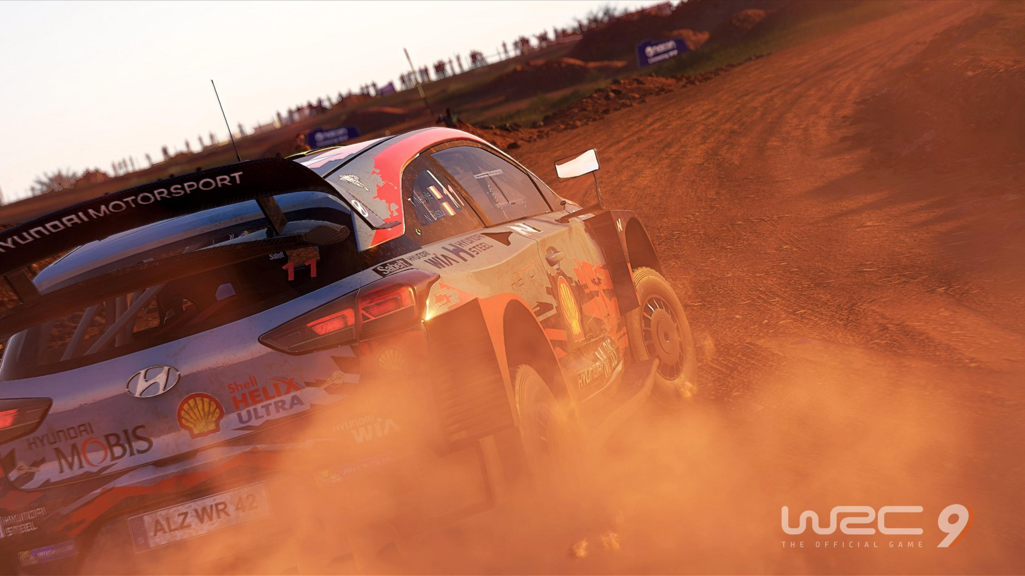 Ein Rallyeauto fährt durch Staub, mit Zuschauern im Hintergrund.