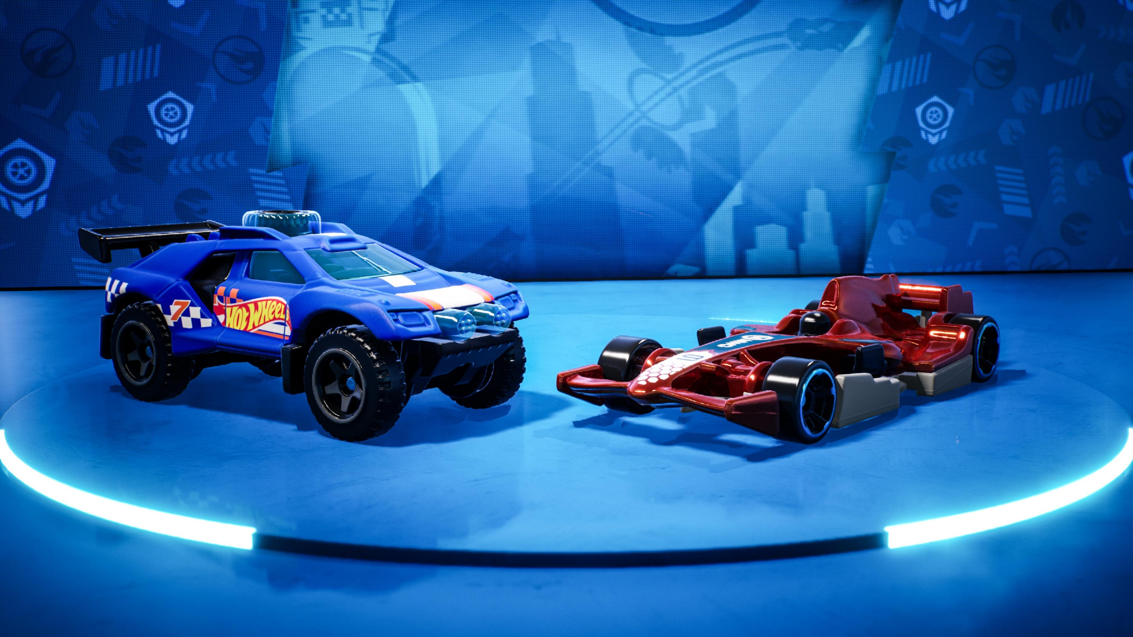 Un'auto fuoristrada blu Hot Wheels e un'auto da corsa F1 rossa su superficie blu.